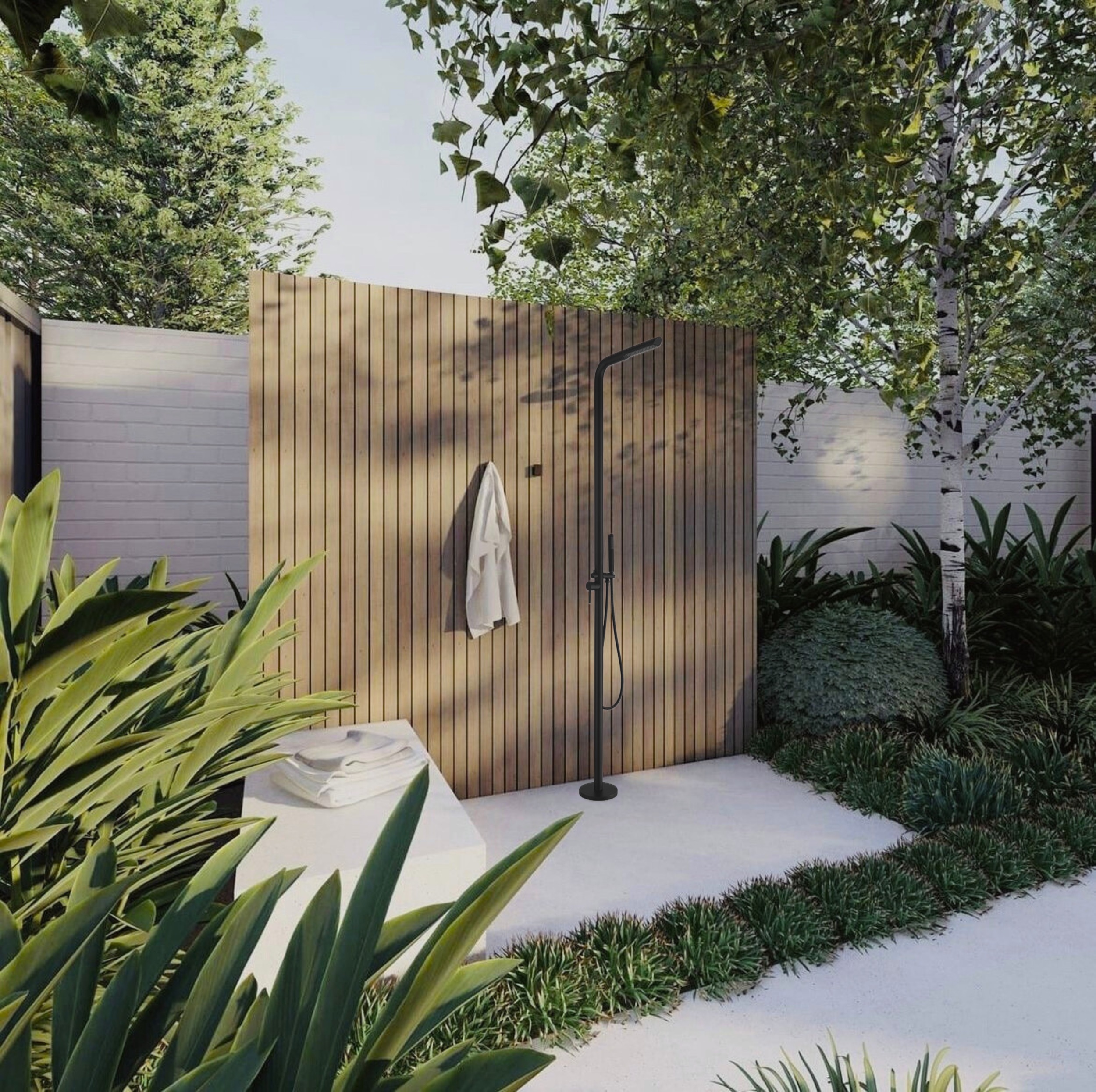 Outdoor shower with black showerhead and a wooden privacy wall, surrounded by lush greenery and trees.