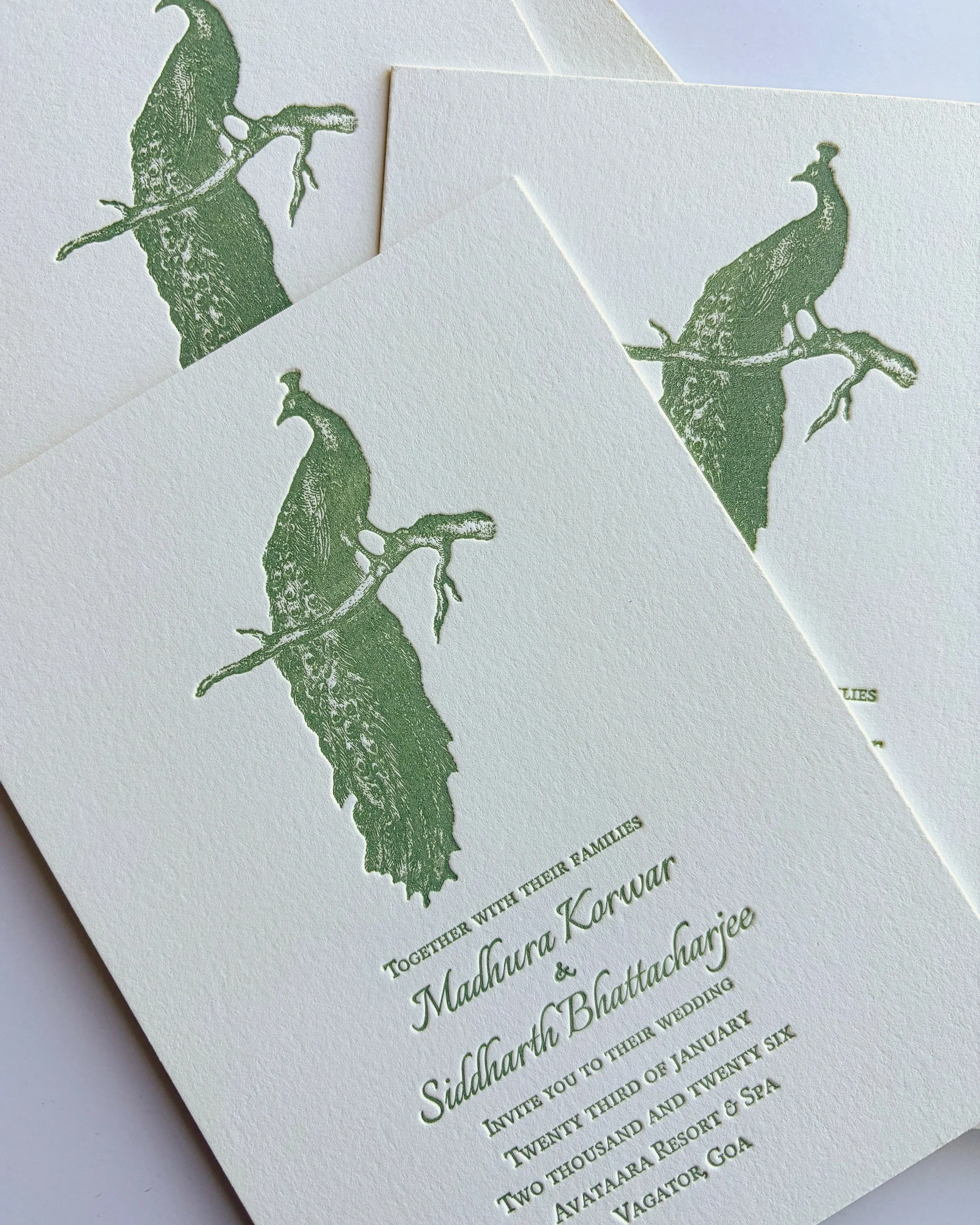 Custom letterpress wedding invitation with green peacock silhouette and minimal text on thick cardstock.