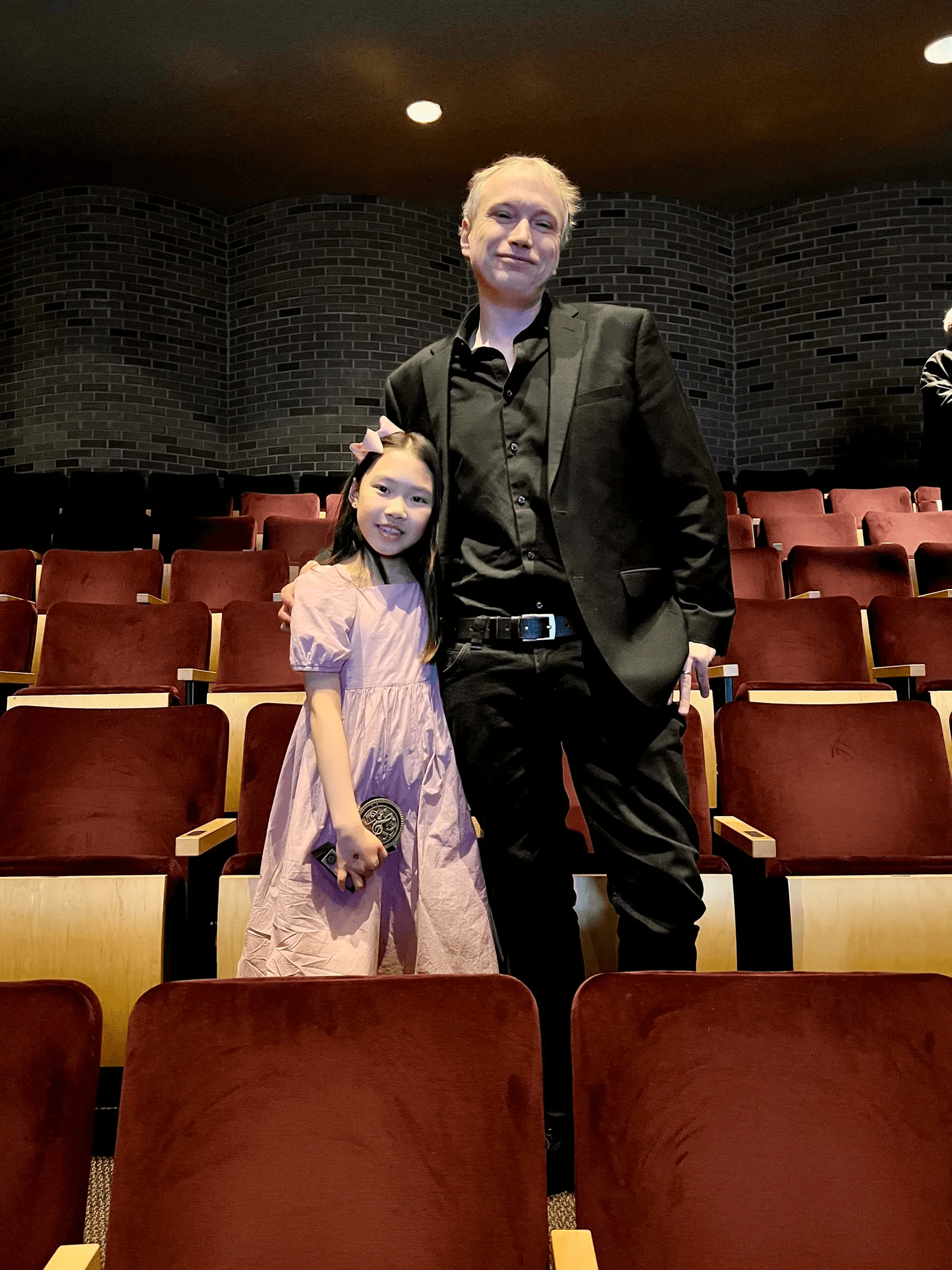 girl and man standing in a theatre posing for a picture