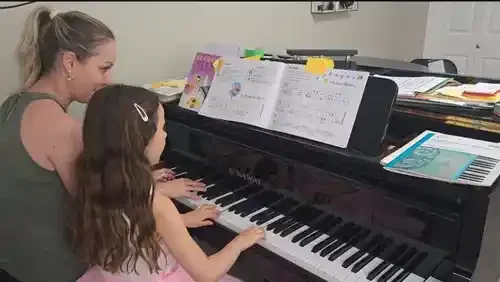 older woman and young woman playing the piano