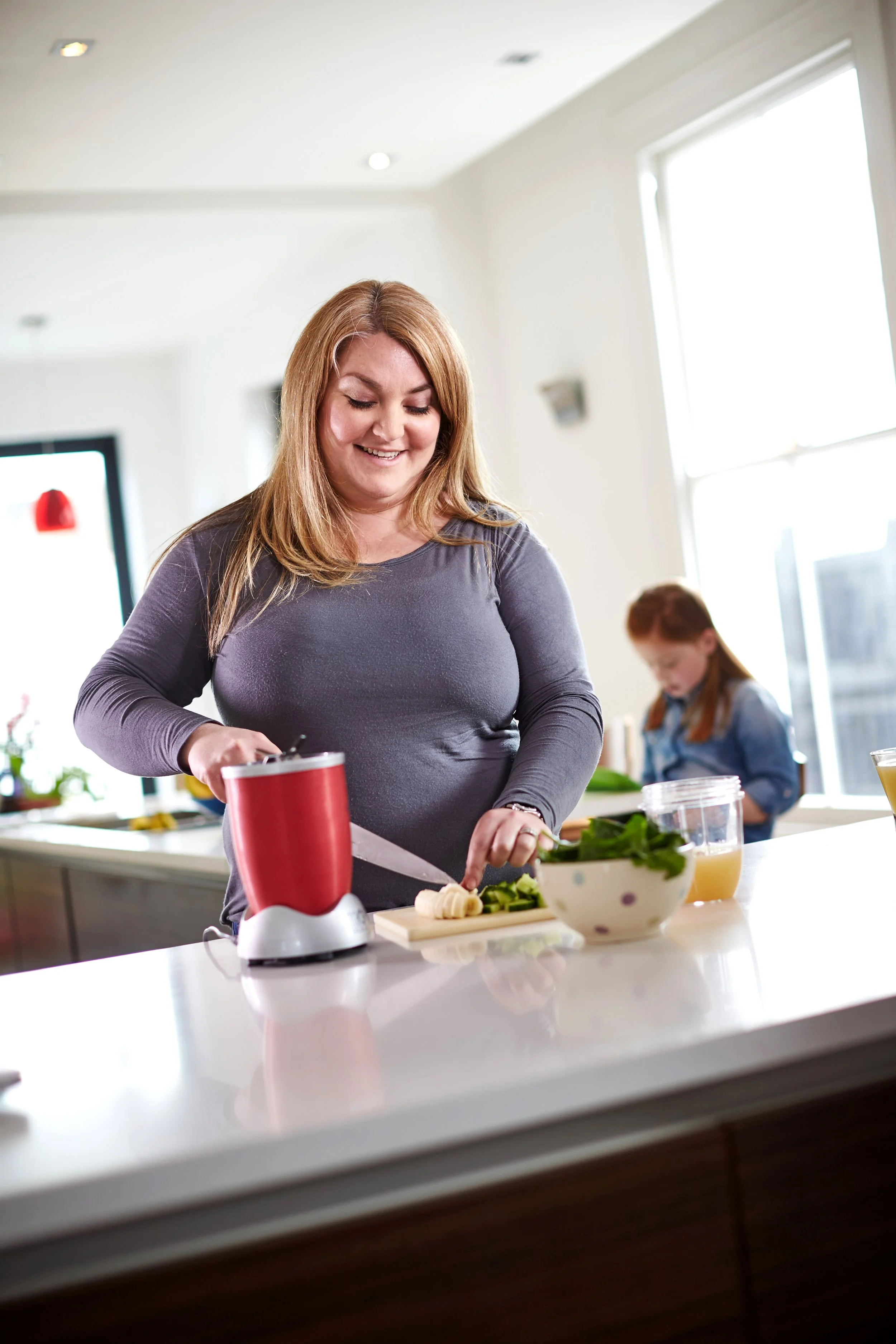Woman cutting vegetables at a kitchen counter
