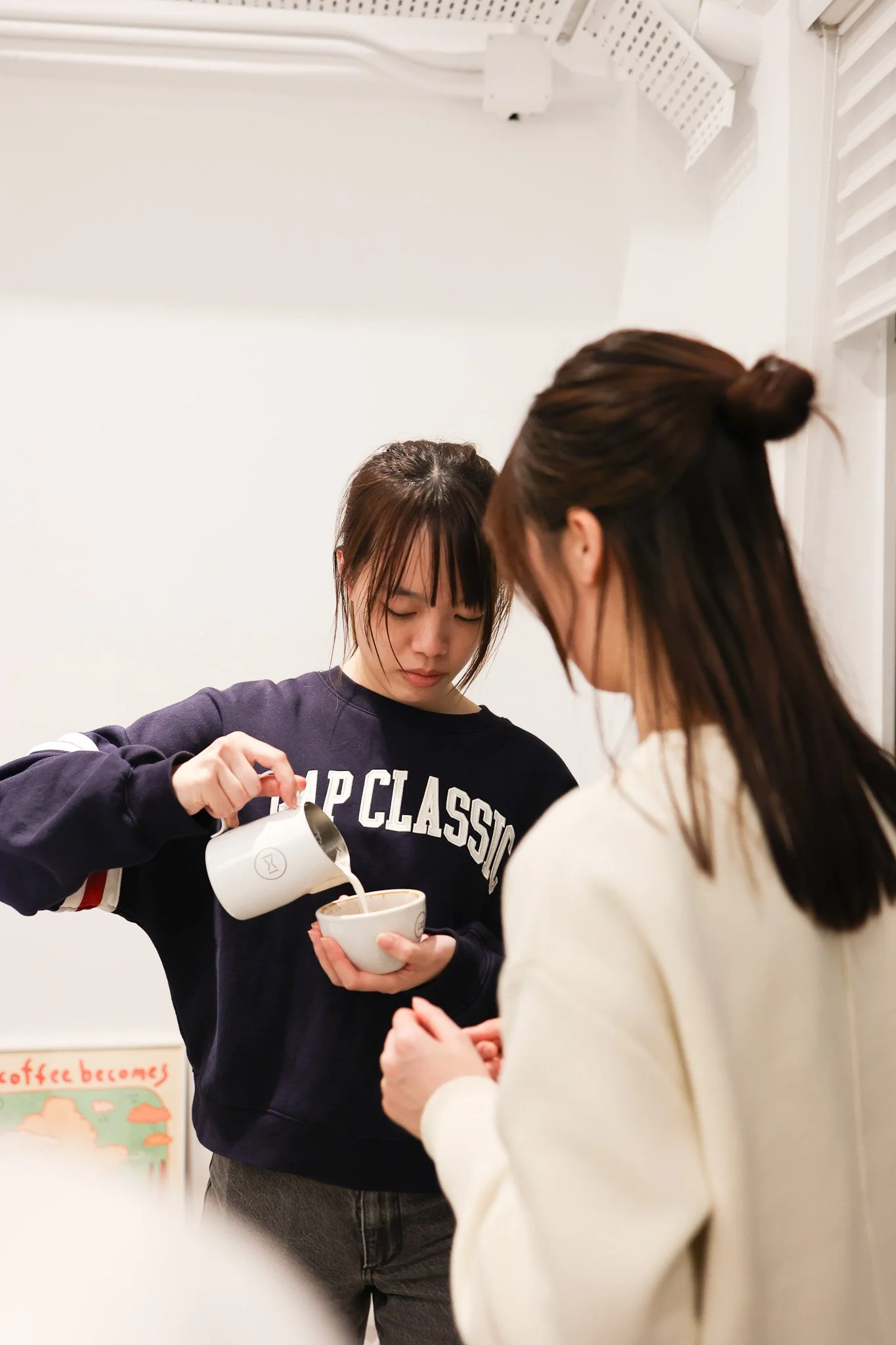 Champion barista coaching a beginner latte art pour at Pause It Lai Chi Kok.