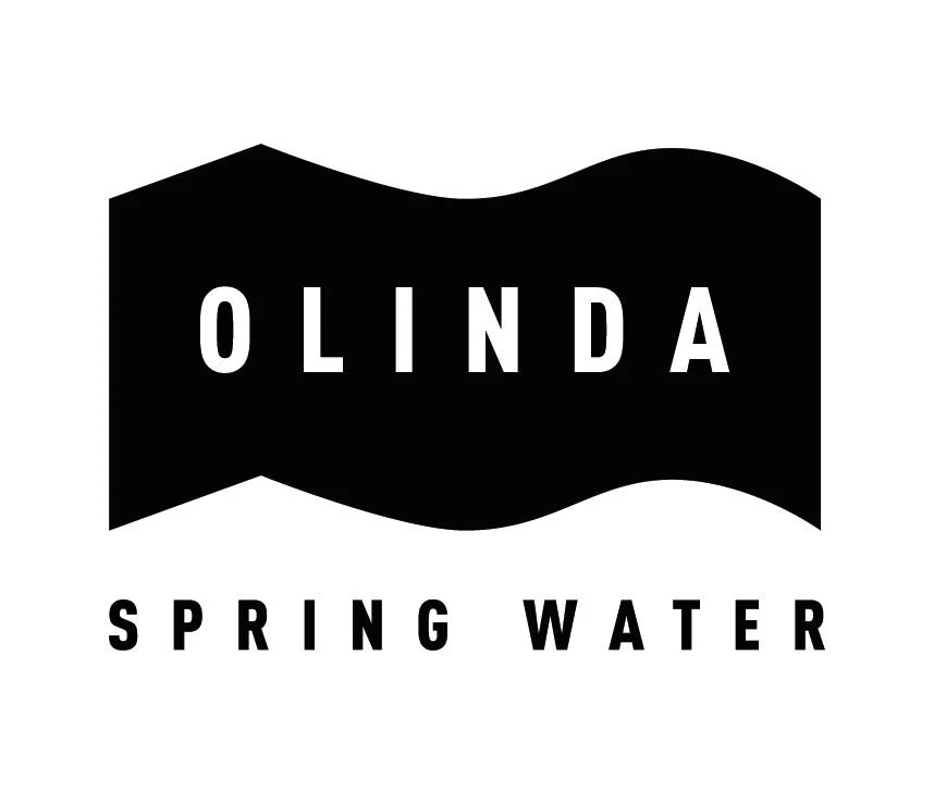 Black logo with wavy shape, white text reads 'OLINDA' in the center and 'SPRING WATER' below.