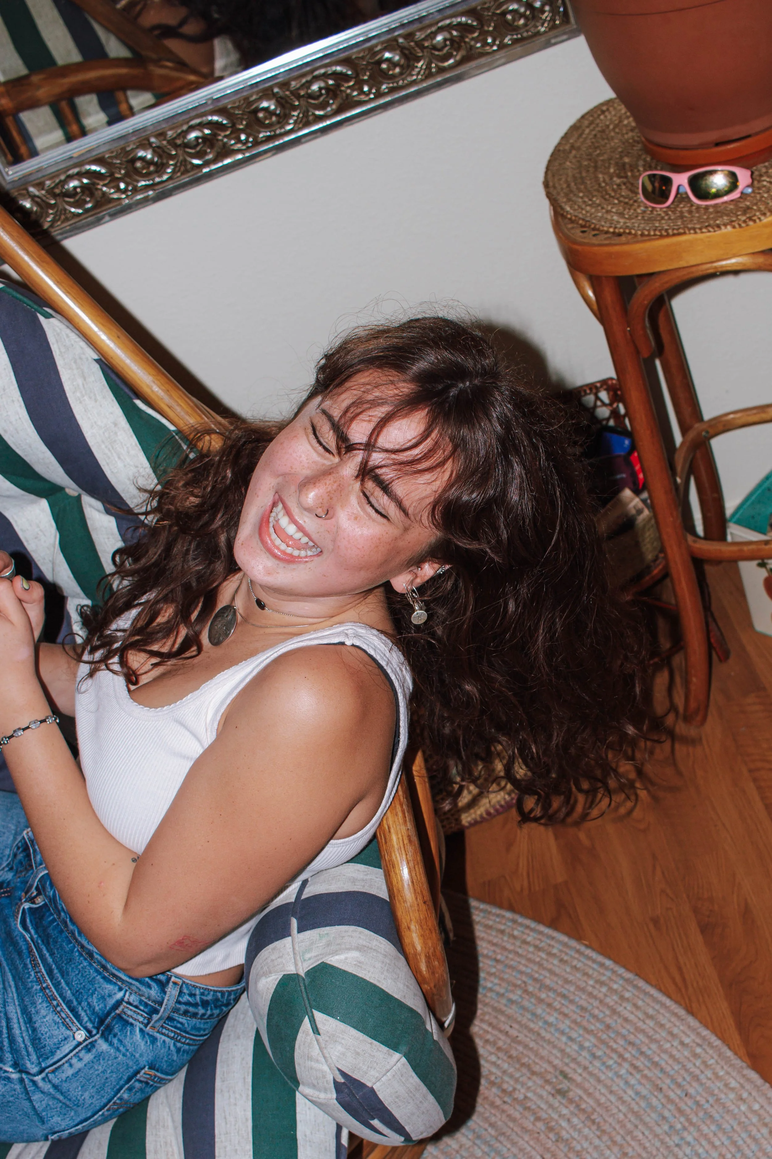 woman leaning over chair and laughing