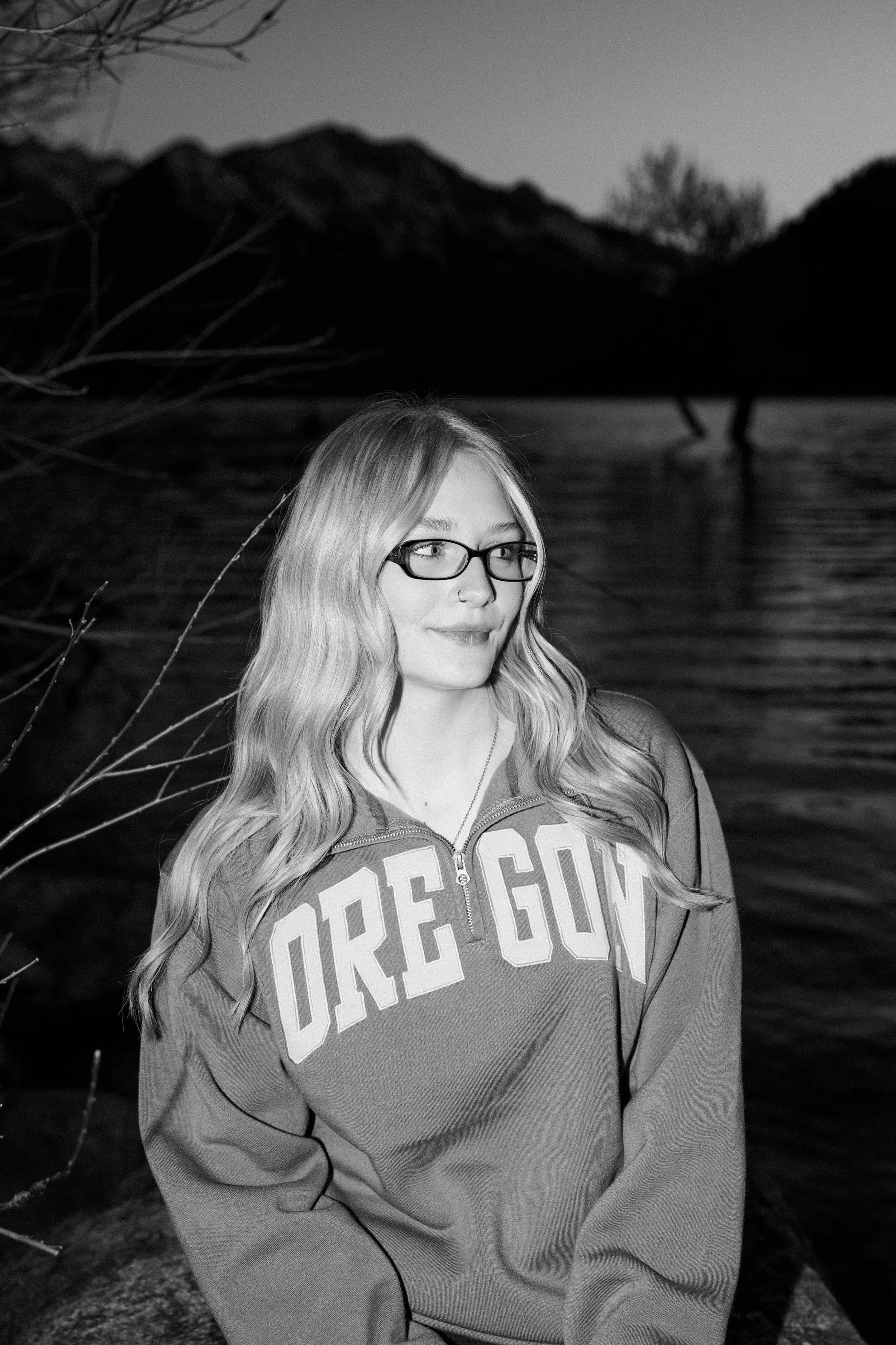 girl smiles in an oregon sweatshirt in front of lake