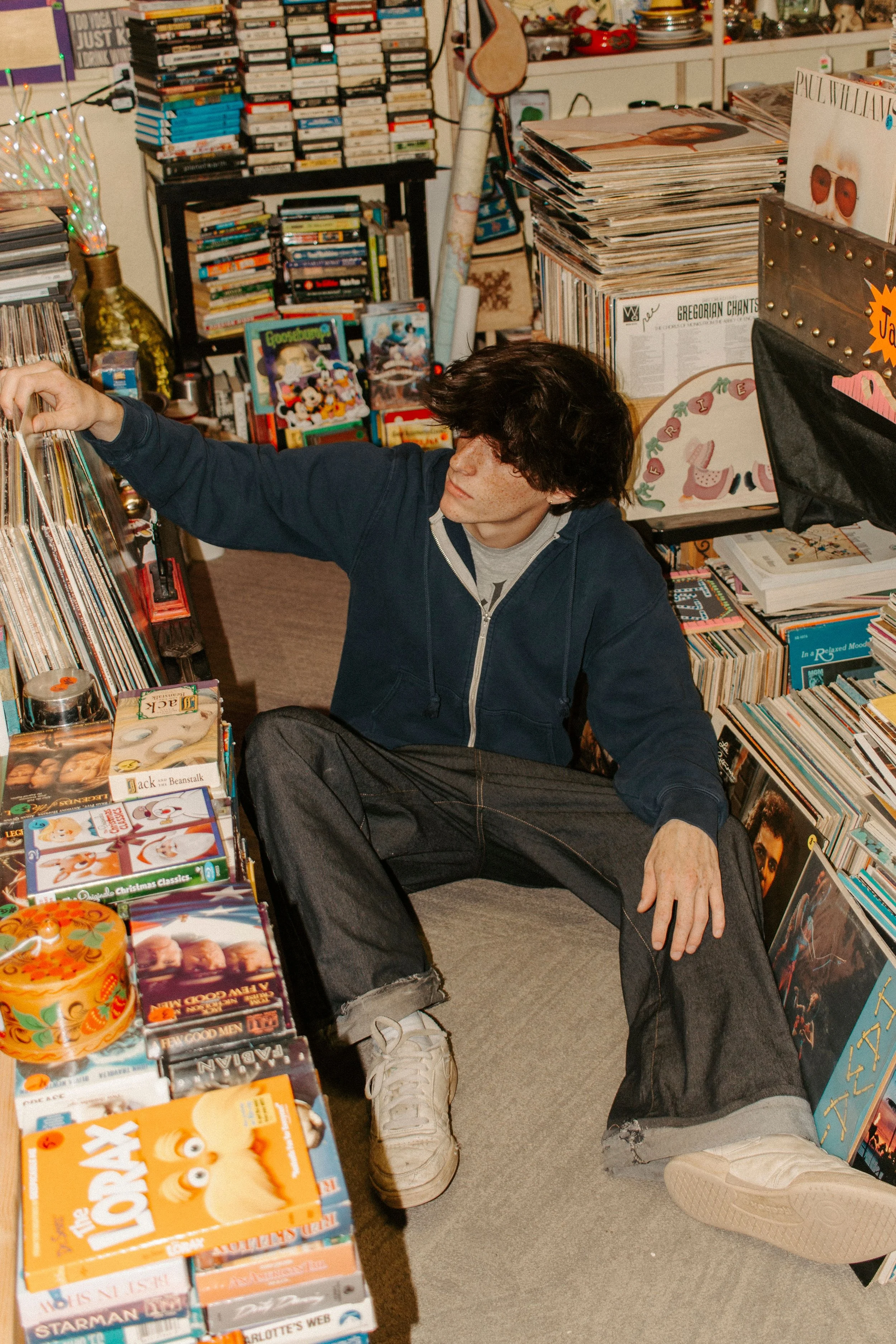 boy sits on floor looking through records