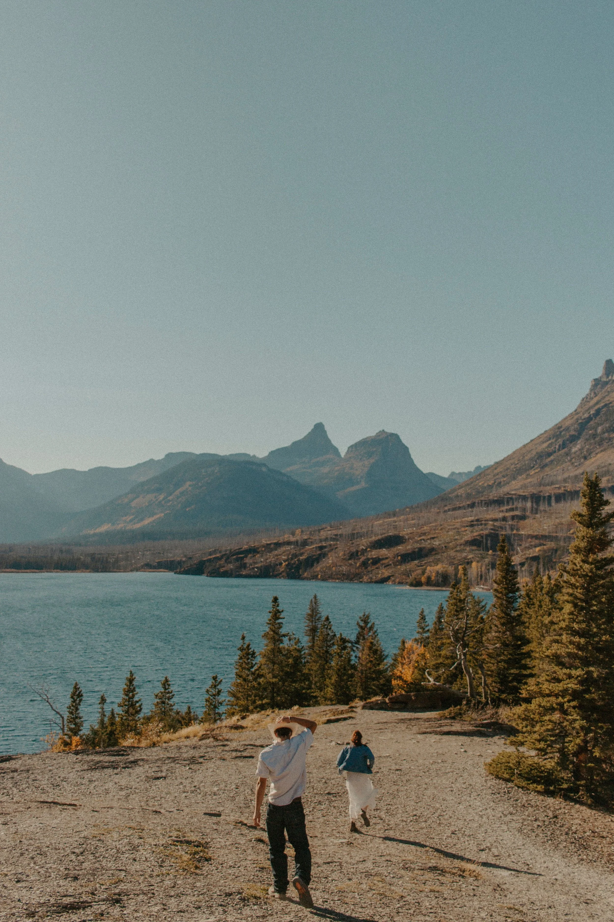 couple runs down hill to lake