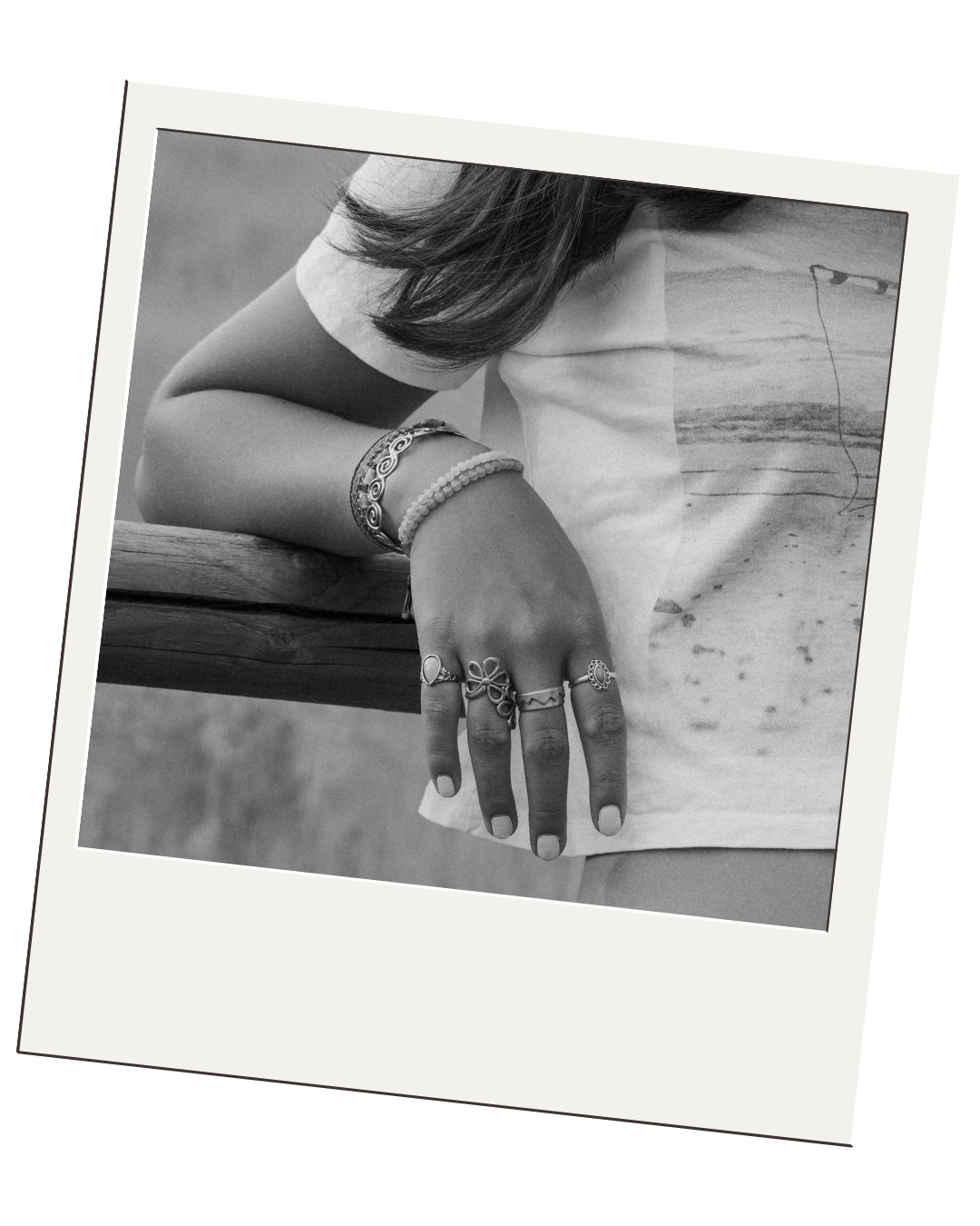 senior drapes hand with rings over wood post