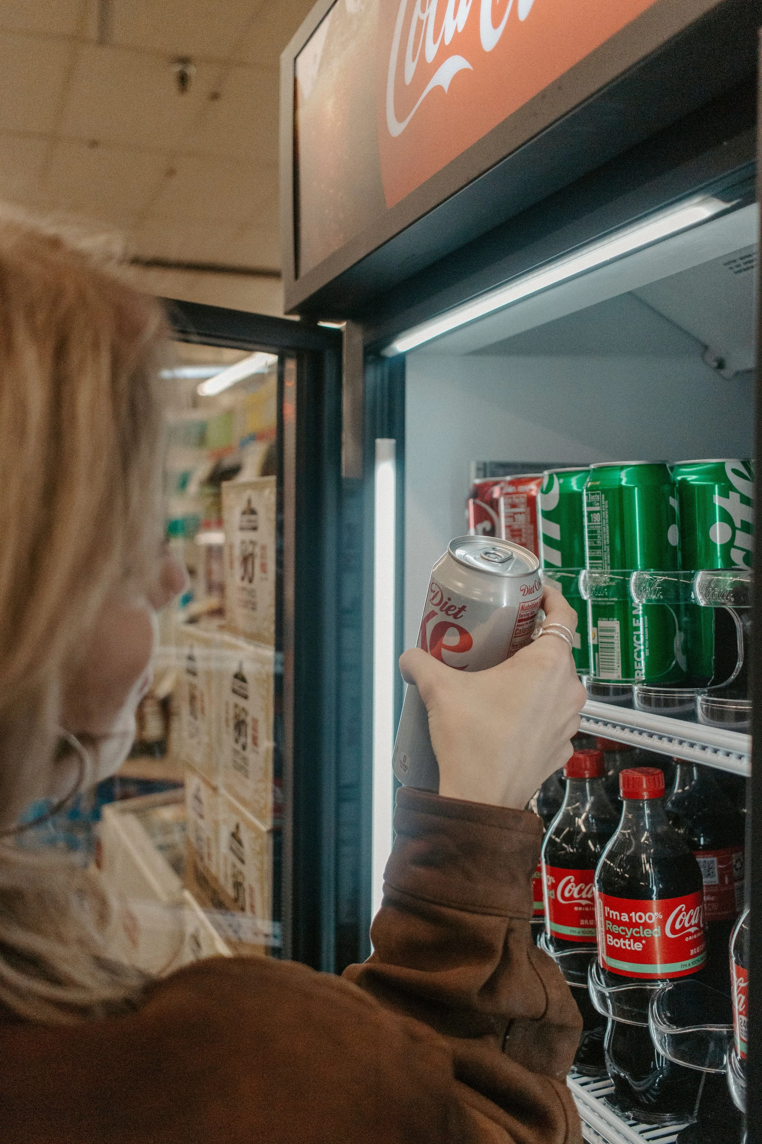 girl grabs diet coke out of cooler in missoula grocery store