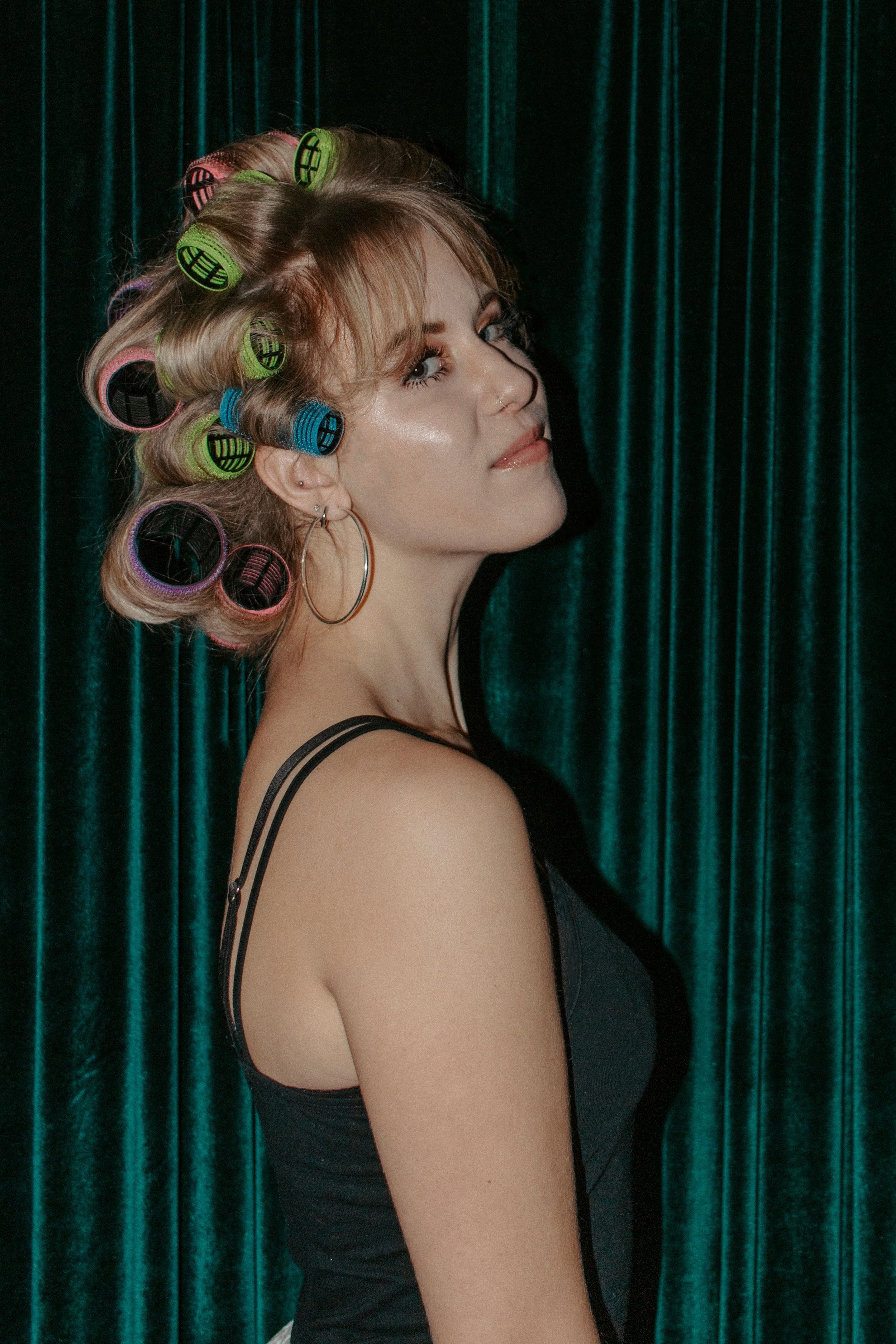 girl has rollers in her hair while looking to the side