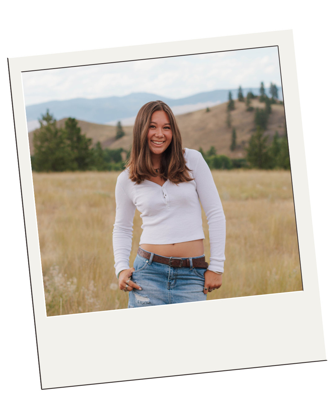 girl smiling in front of mountains and trees