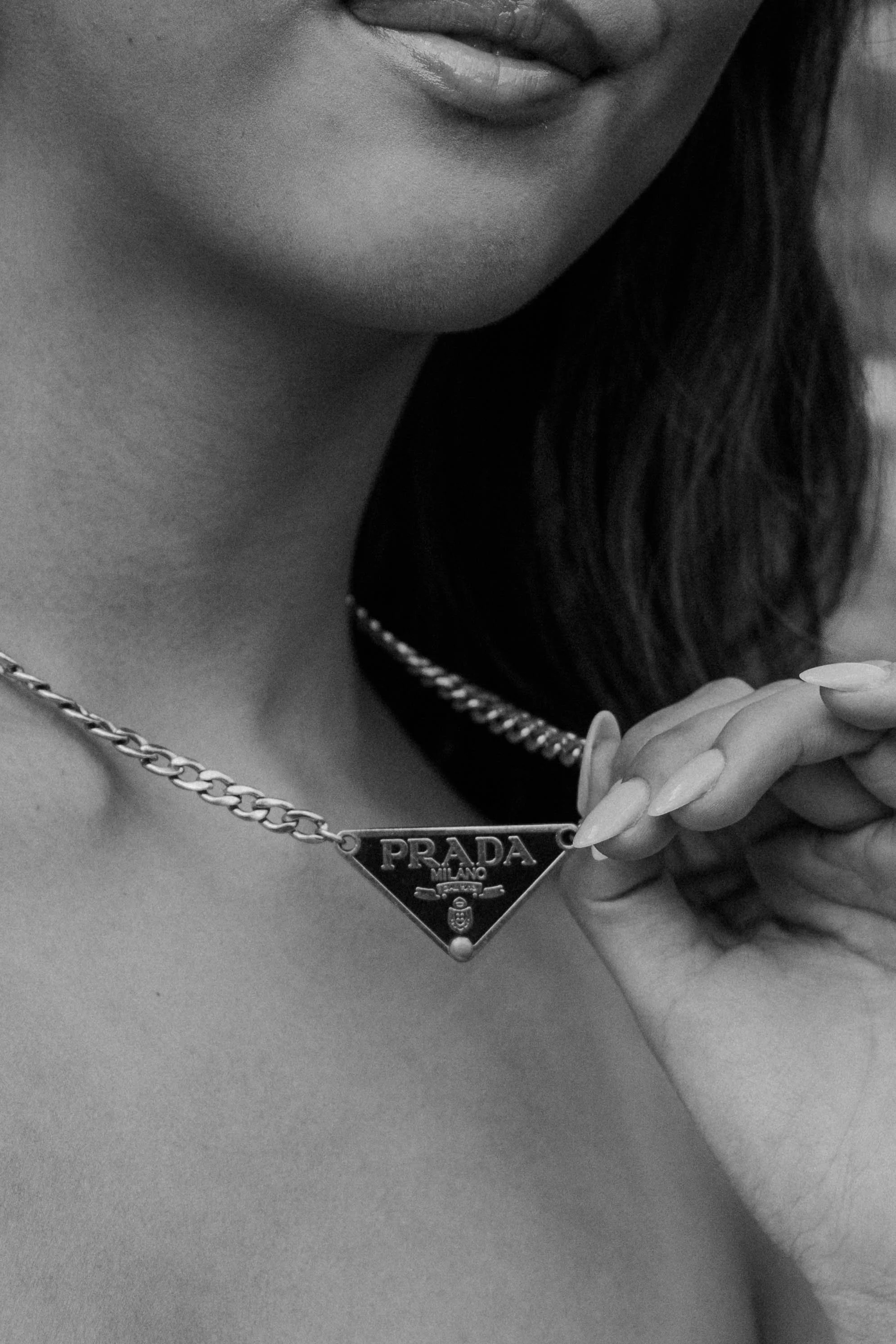 girl holds prada necklace