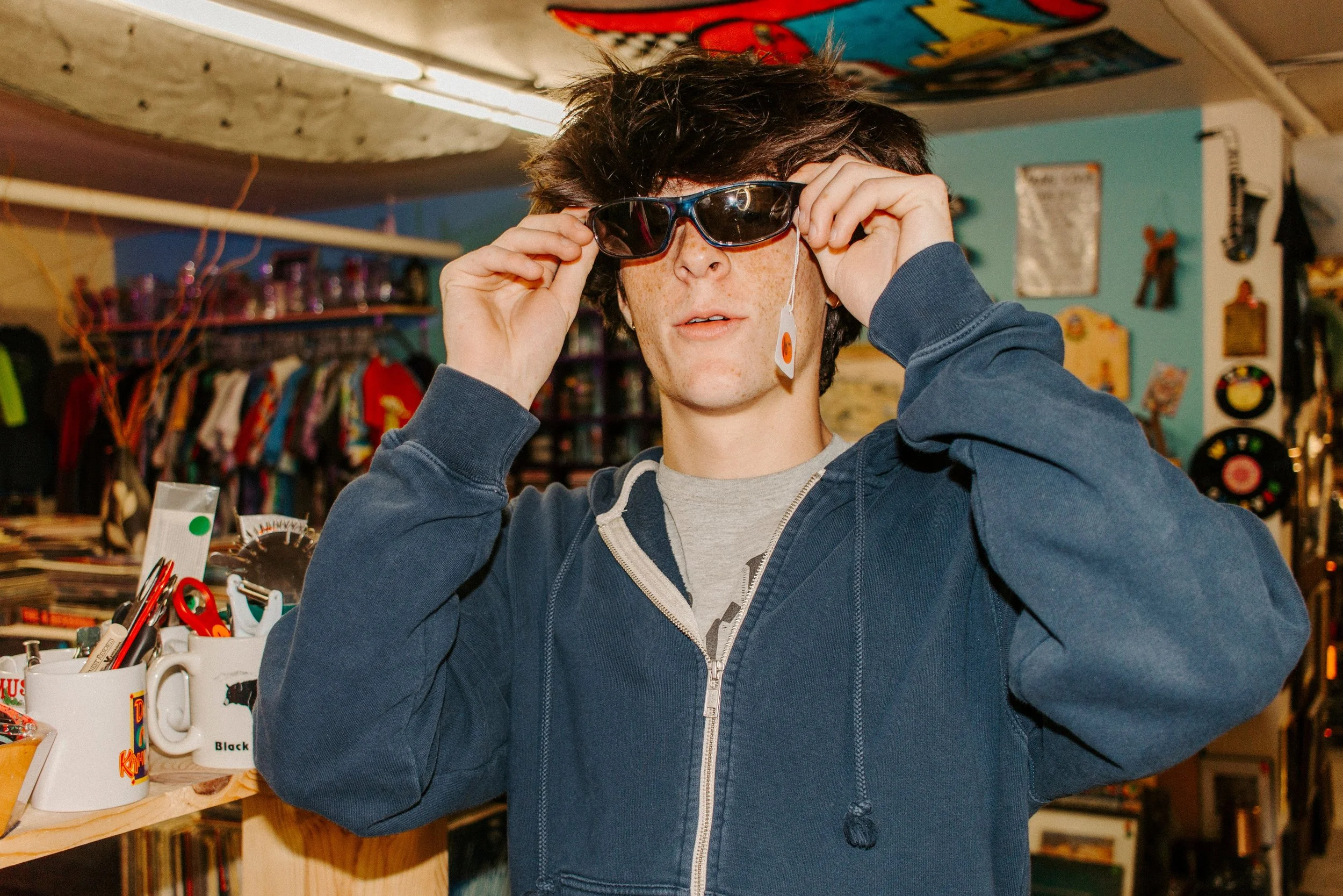 boy tries on glasses at vintage store
