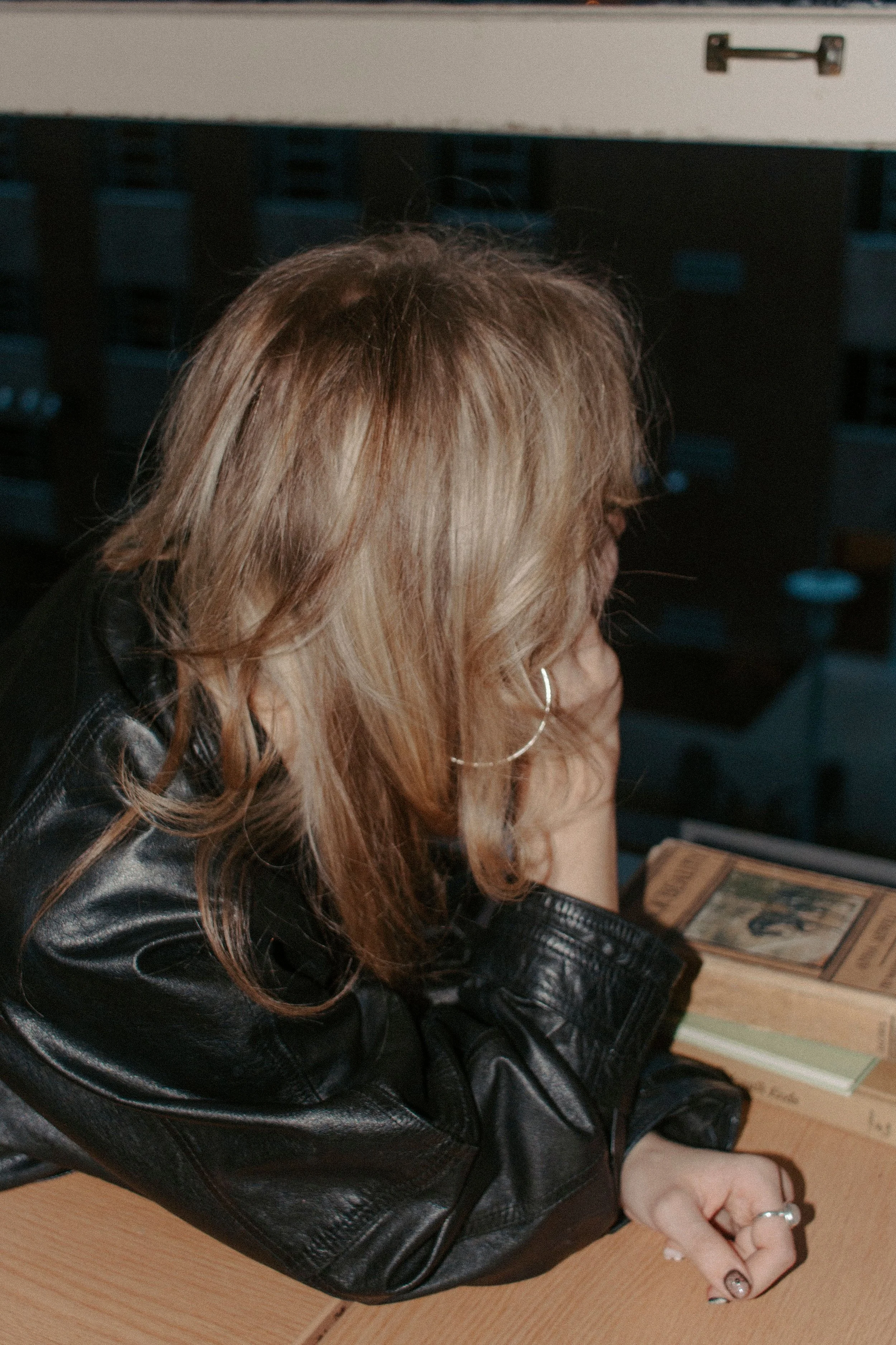 girl leans on hand looking out window