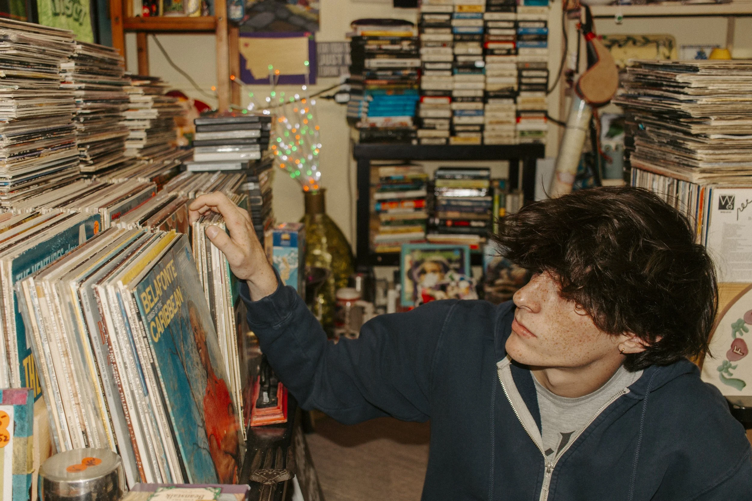 boy looks through records at antique shop