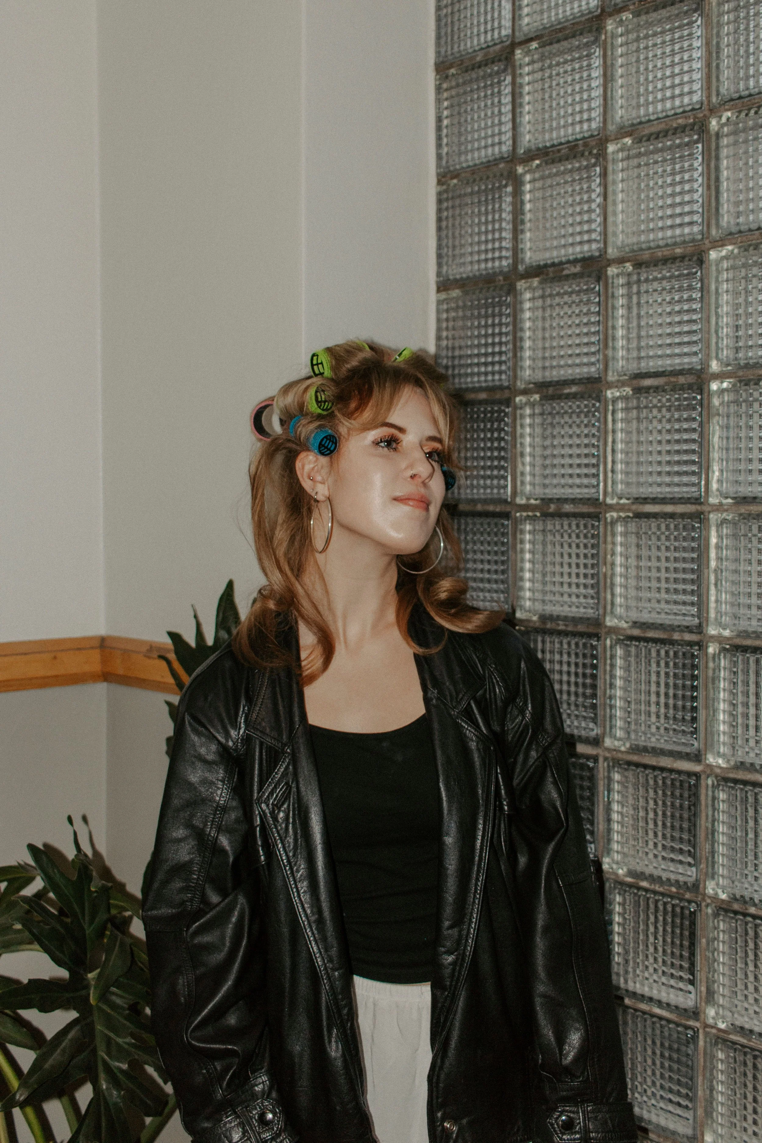 girl looks to the side with curlers in her hair