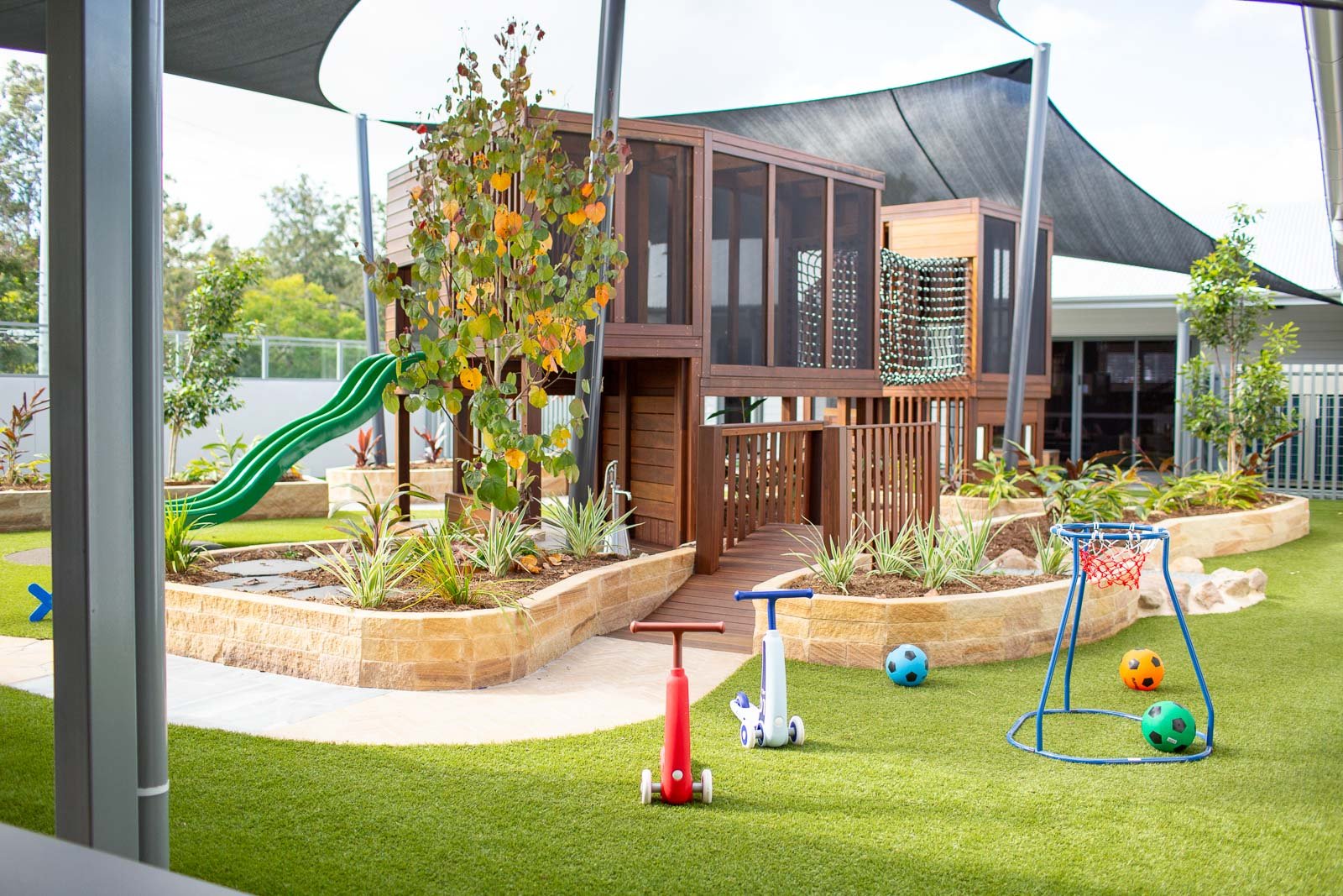 Childcare Landscape Design experts with custom bespoke timber fort. Bike Track Sandstone Walls