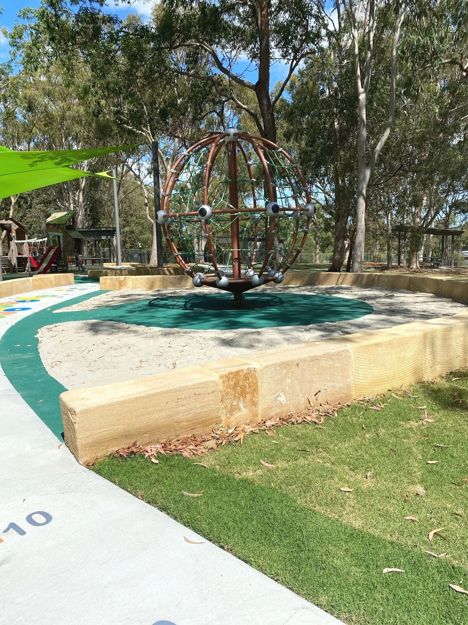 Playground equipment at Hanover Drive Park Alexandra Hills with children playing on climbing structures and slides

