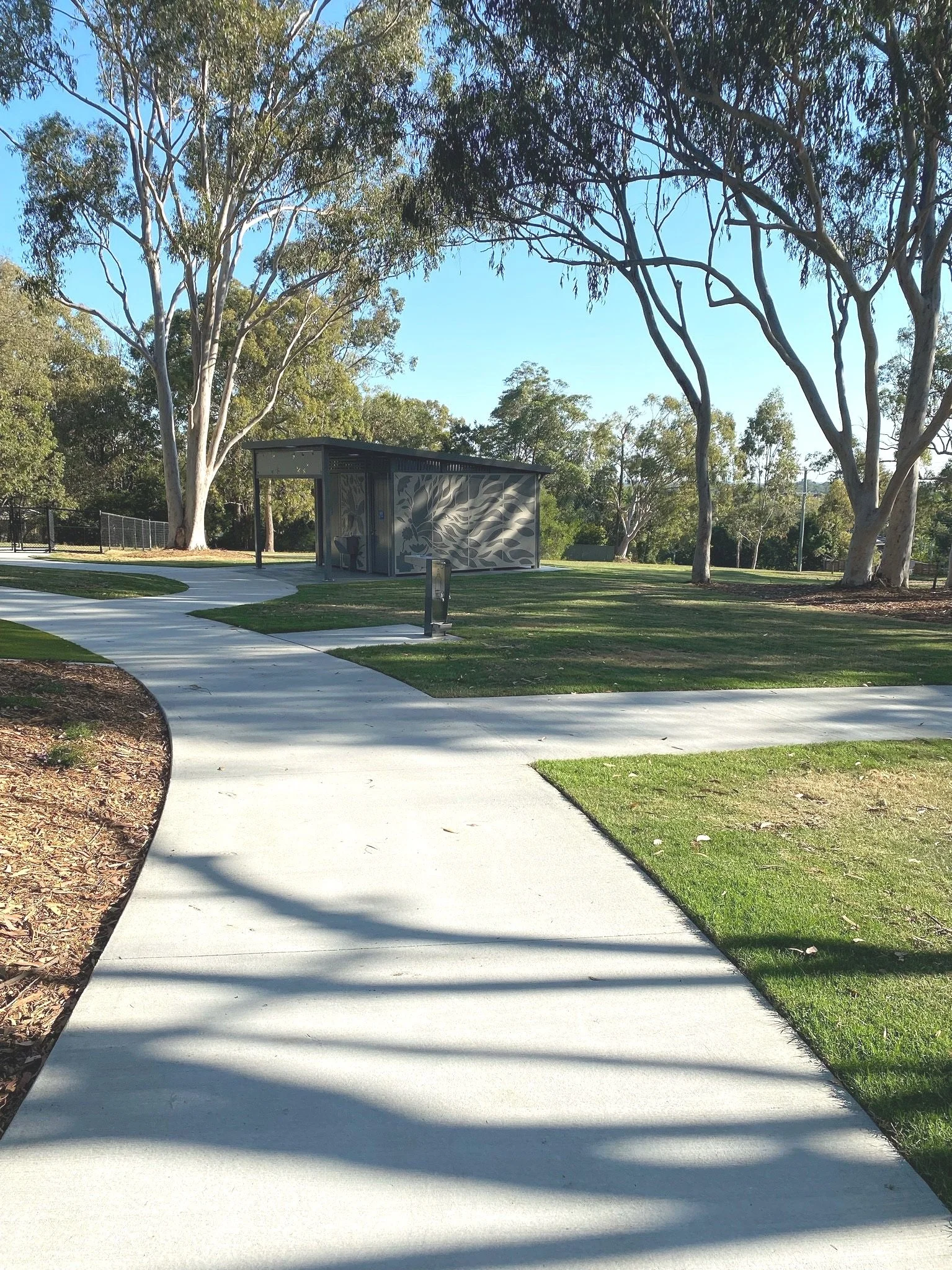 Pathways and landscaped gardens connecting play zones at Hanover Drive Park Alexandra Hills

