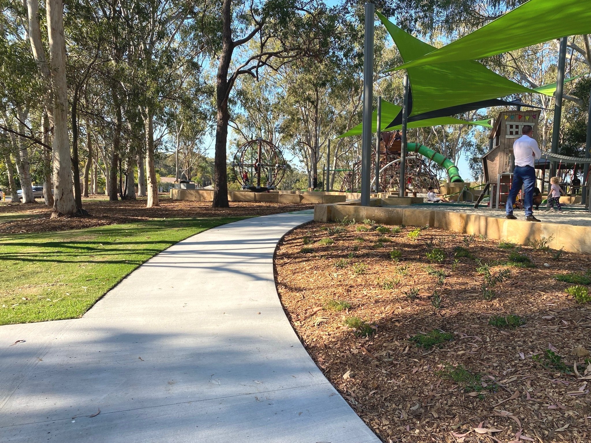 Pathways and landscaped gardens connecting play zones at Hanover Drive Park Alexandra Hills