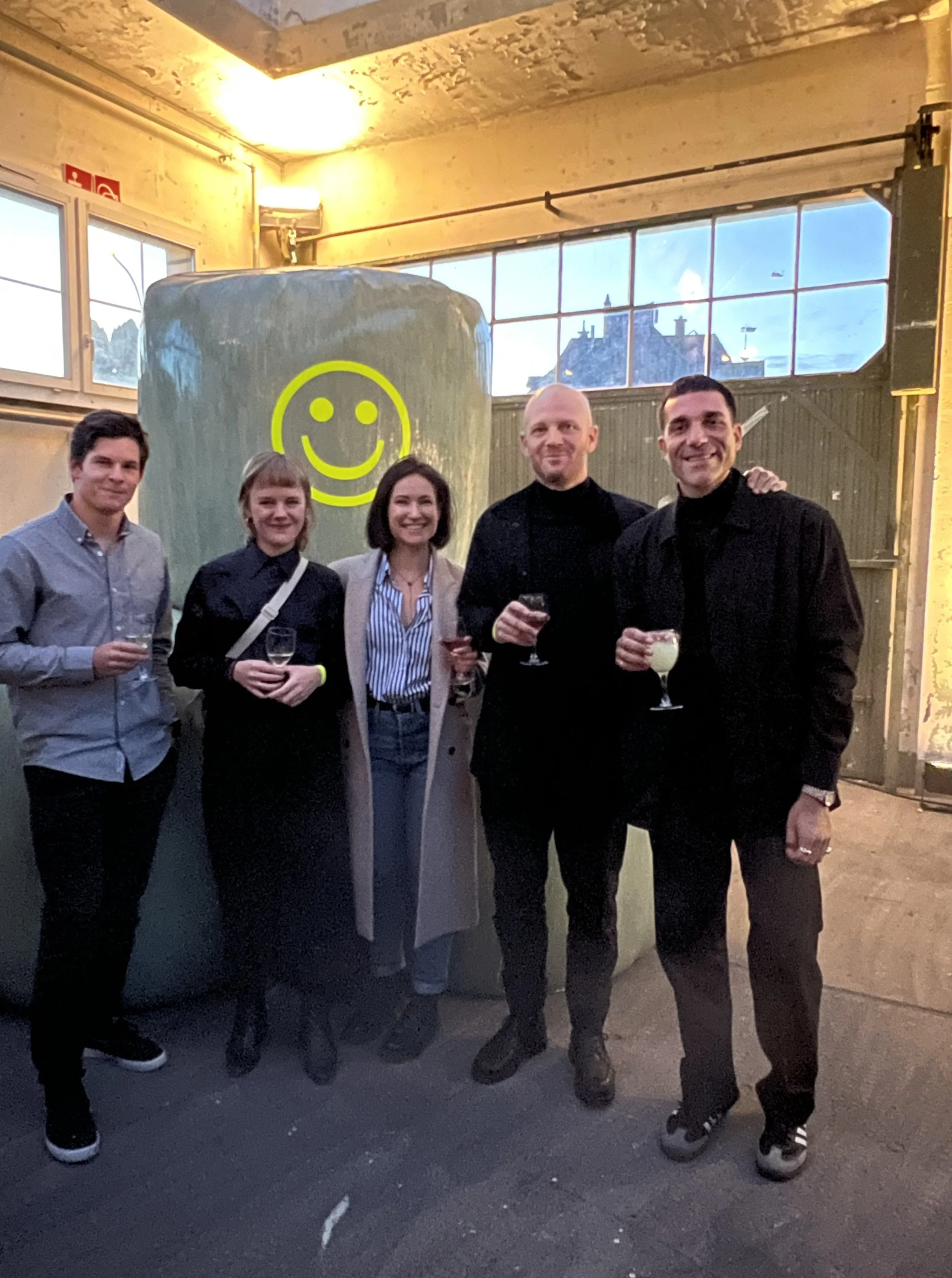 Fünf Menschen, die stehen, mit einem Smiley im Hintergrund