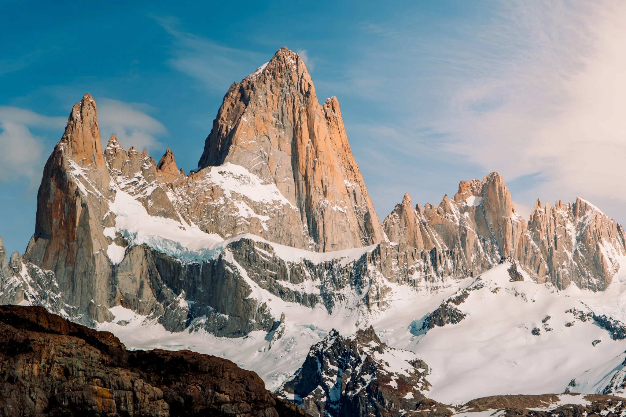 Snow-covered mountain peaks with a clear blue sky in the background.
