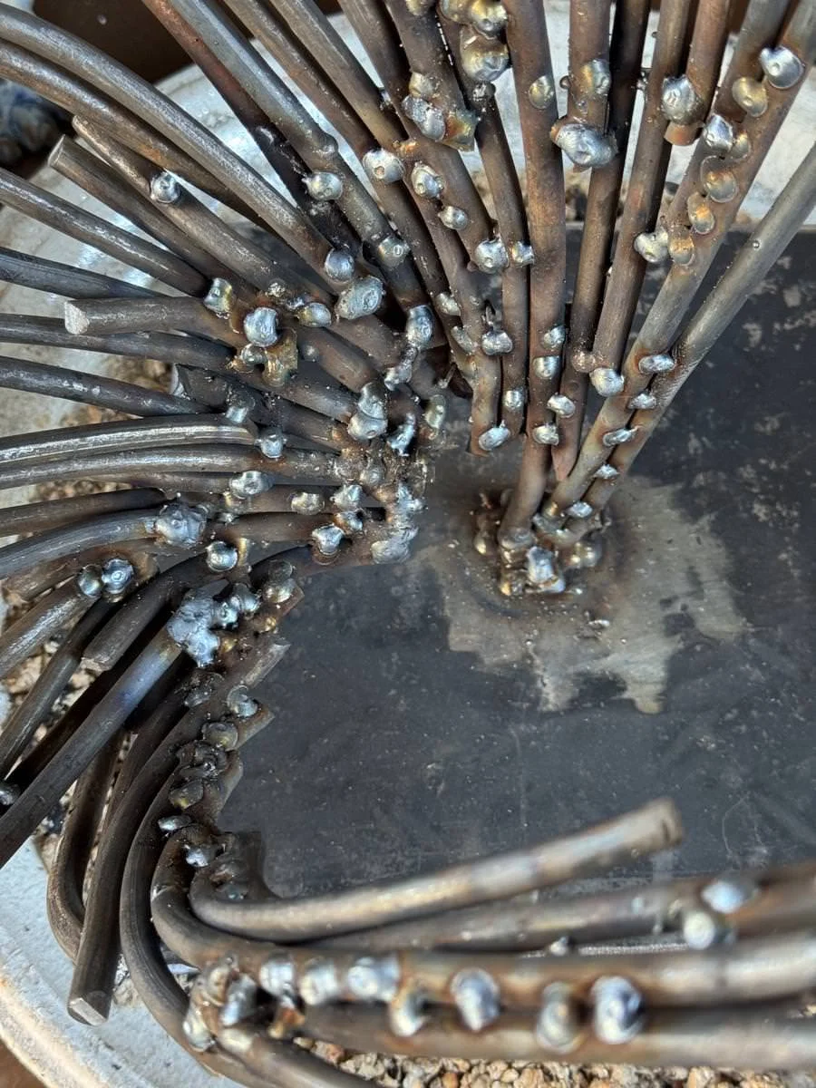 Nahaufnahme einer Metallskulptur mit verschweißten Stäben.