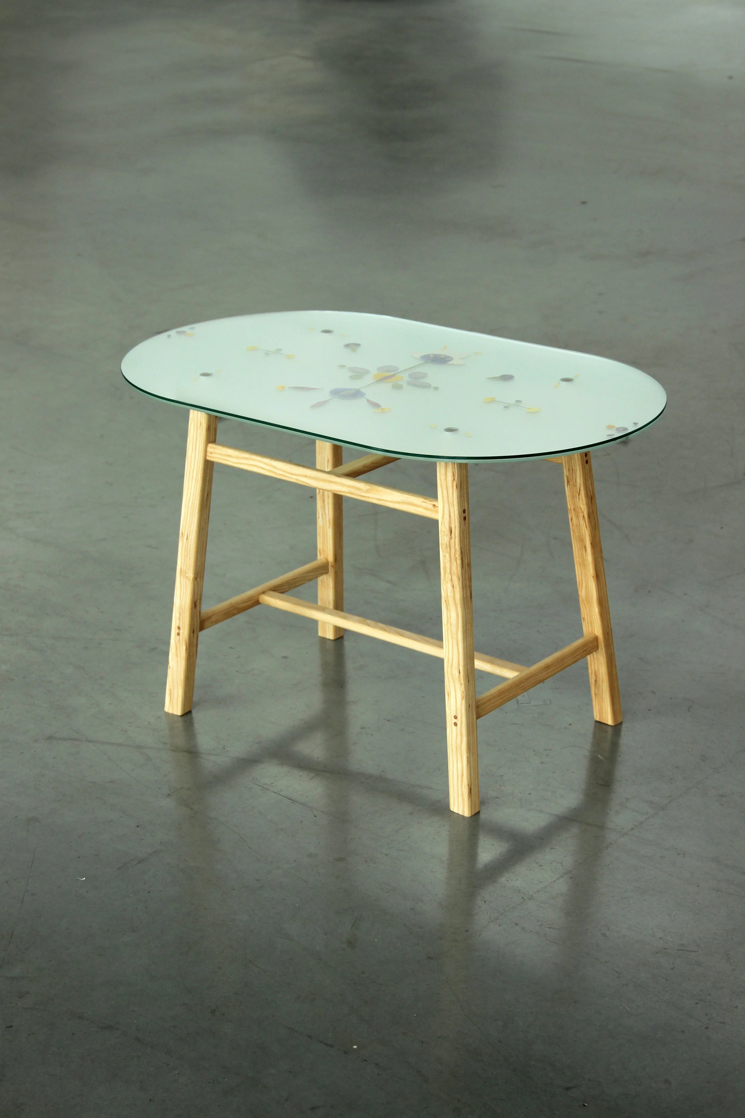 Coffee table with dried flower petal ornaments, made of glass and wood