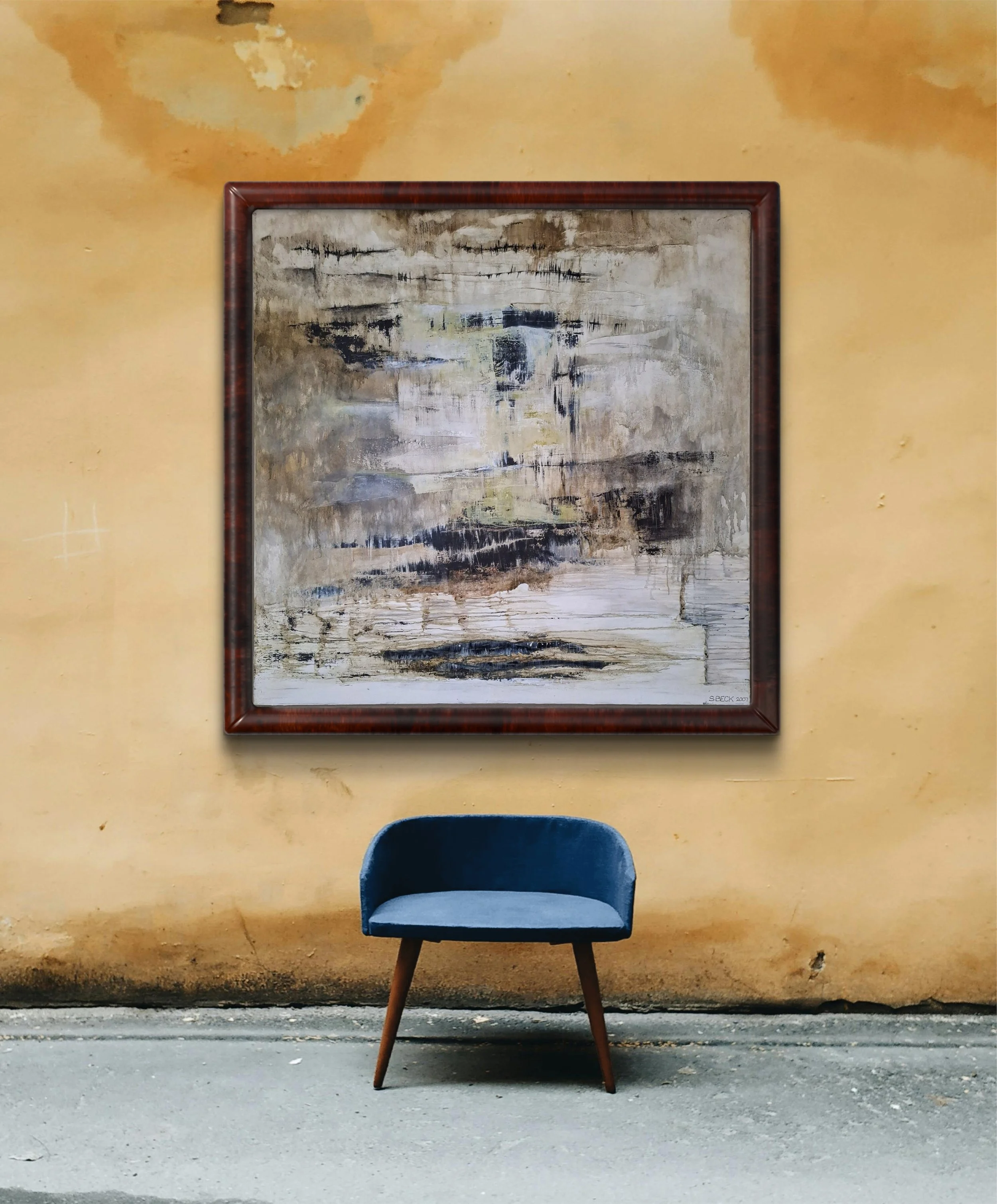 A blue upholstered chair with wooden legs is placed in front of an abstract painting on a yellowish wall.