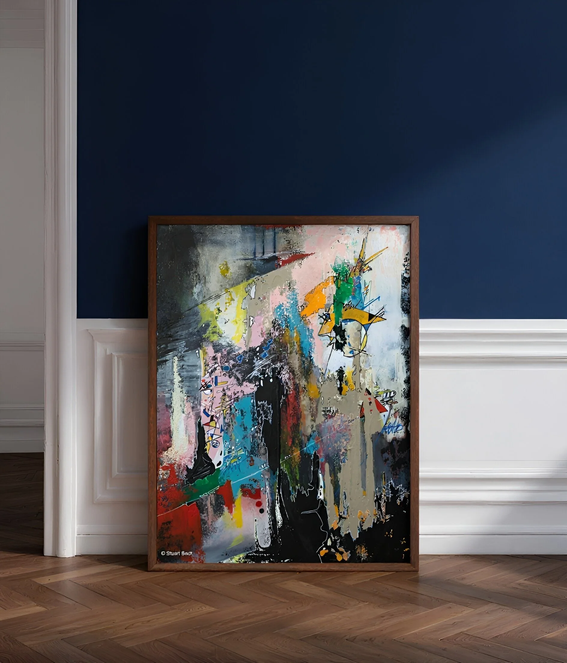 An abstract painting with vibrant colors, placed on a hardwood floor against a dark blue wall, within a wooden frame.