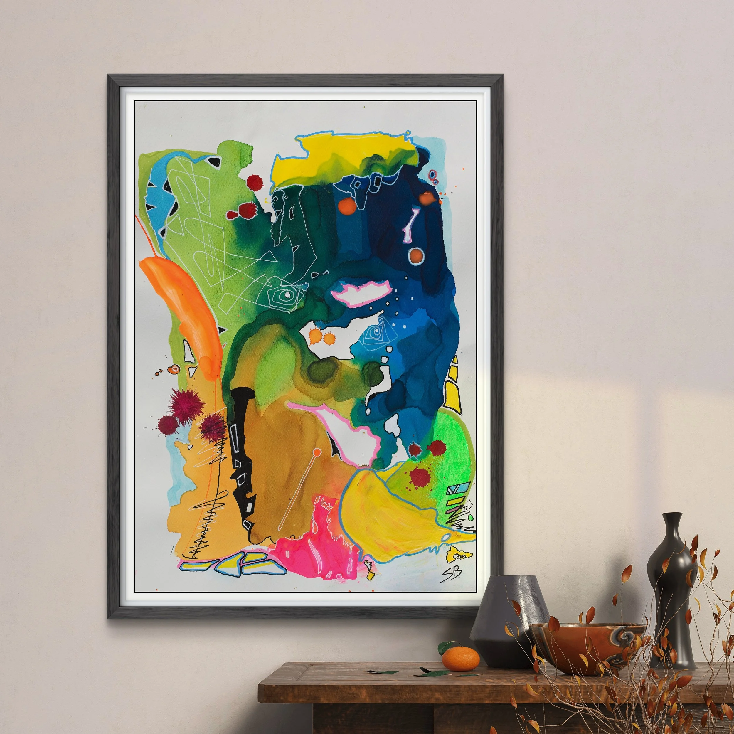 Abstract colorful painting with shapes and lines in shades of blue, green, yellow, orange, pink, and black, framed on a white wall near a wooden table with vases and a small orange fruit.