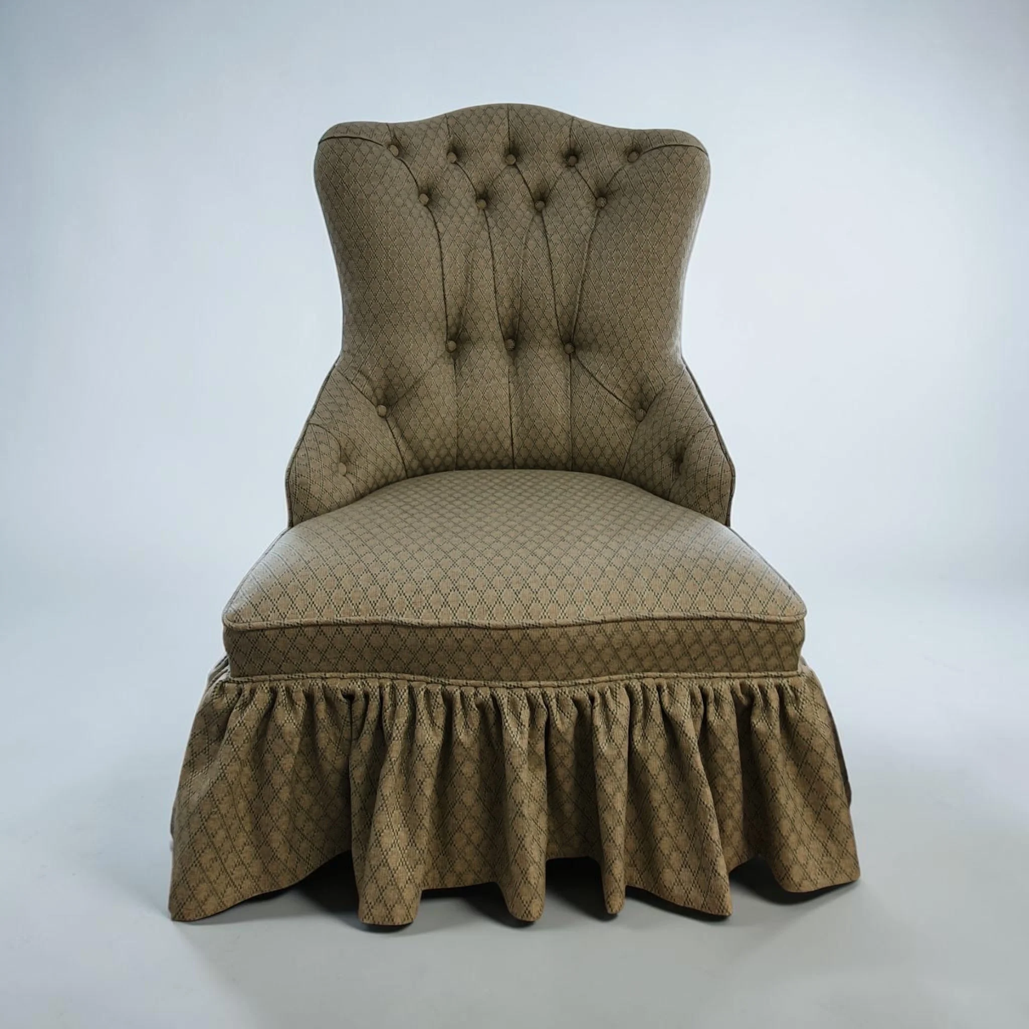 A vintage upholstered armchair with a high back, tufted with buttons, covered in beige patterned fabric, with a puffed skirt at the bottom, set against a plain light background.