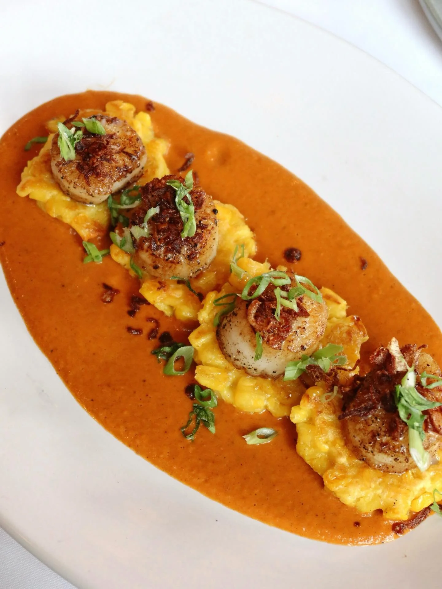 ⭐️ New on the menu at The Boiler Room

Seared Sea Scallops served with saffron corn fritters, tomato coconut masala, scallions, and crispy shallots. A perfect balance of bold flavor and delicate texture in every bite!
