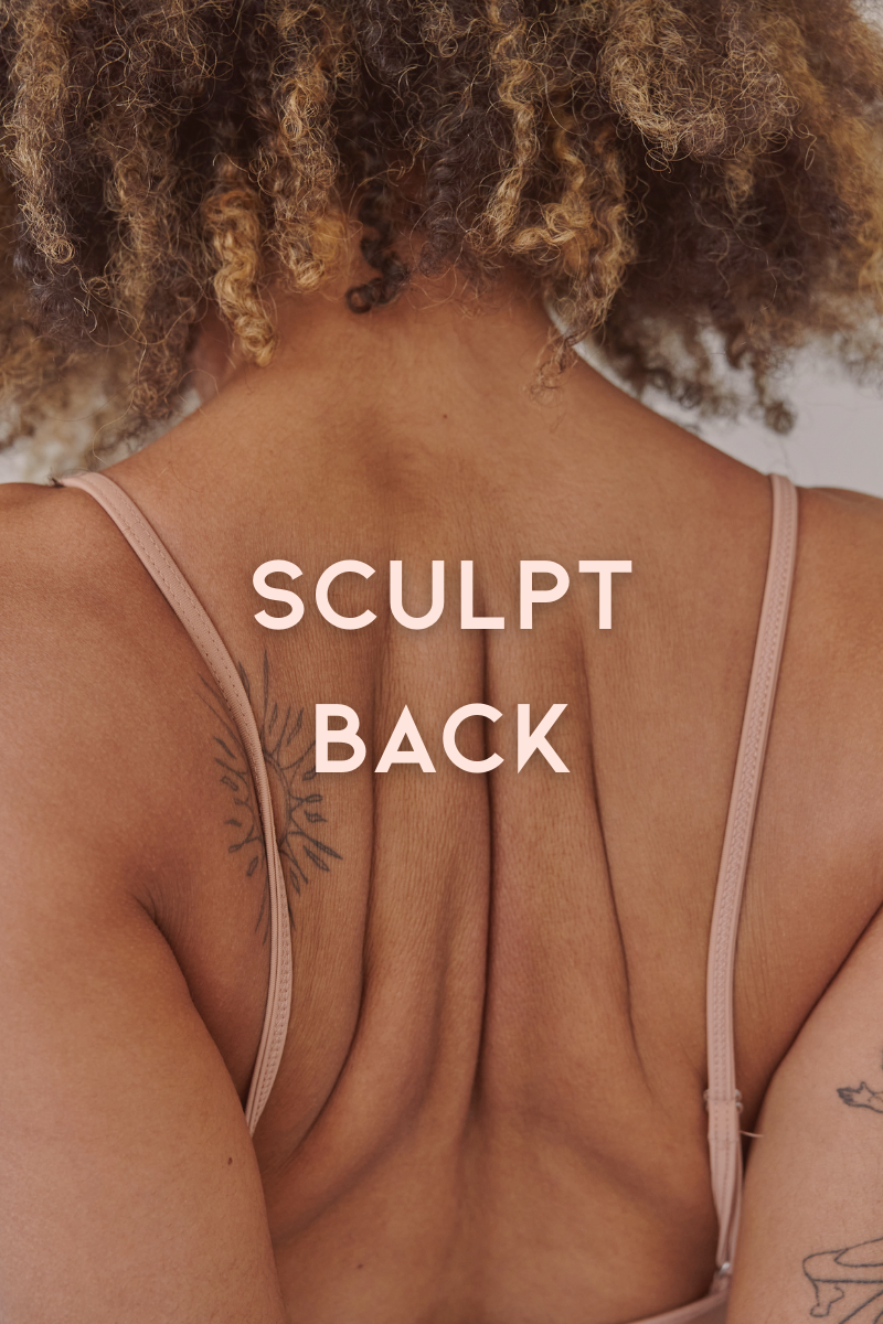 Derrière d'une femme avec des cheveux bouclés, portant un haut beige, montrant son dos avec des tatouages et les lignes de muscles dans le haut du dos.