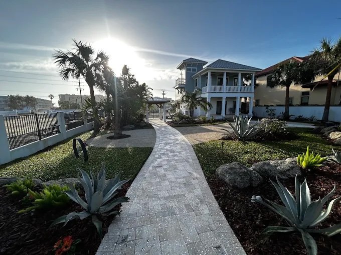 Paver walkway, garden bed installation, and trimmed trees.