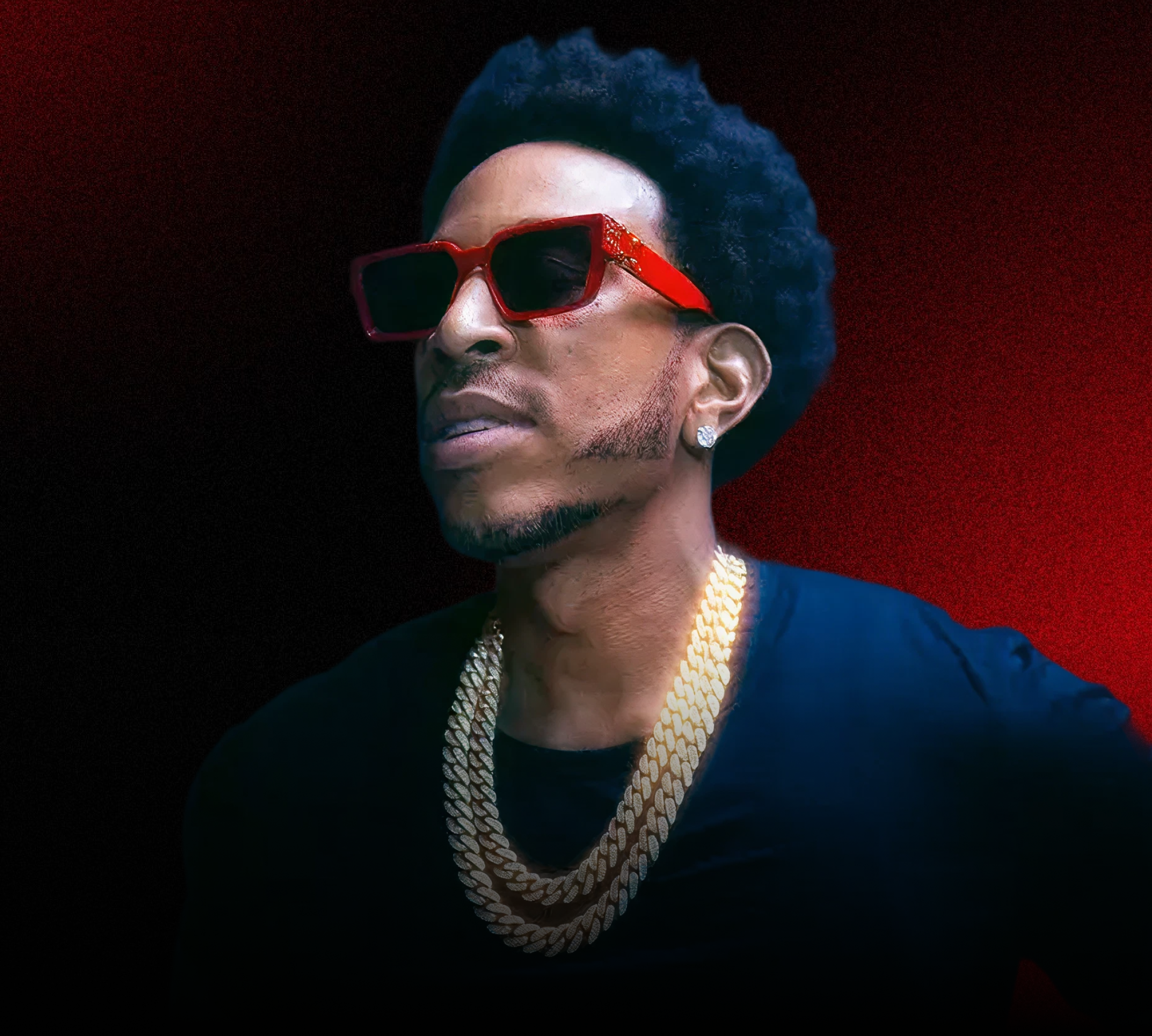 A man with dark hair styled upwards, wearing large red sunglasses, a diamond earring, and a gold chain, against a dark background with red lighting.