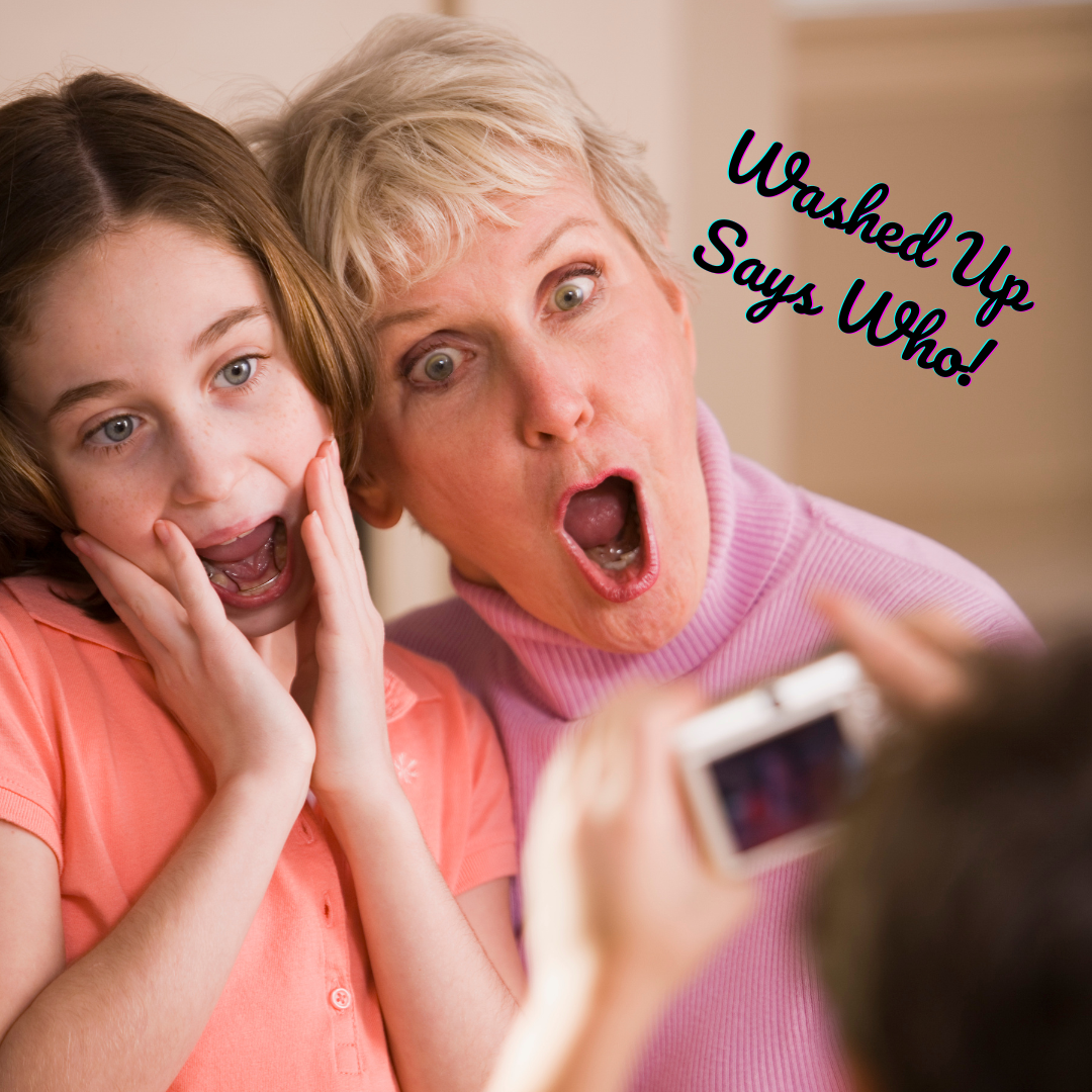 A woman and a girl are surprised as they look at a camera held by someone in front of them. The woman has short, gray hair and is wearing a pink turtleneck; the girl has shoulder-length brown hair and is wearing a peach-colored shirt. They both have wide eyes and open mouths. Text on the image says, 'Washed Up Says Who!'