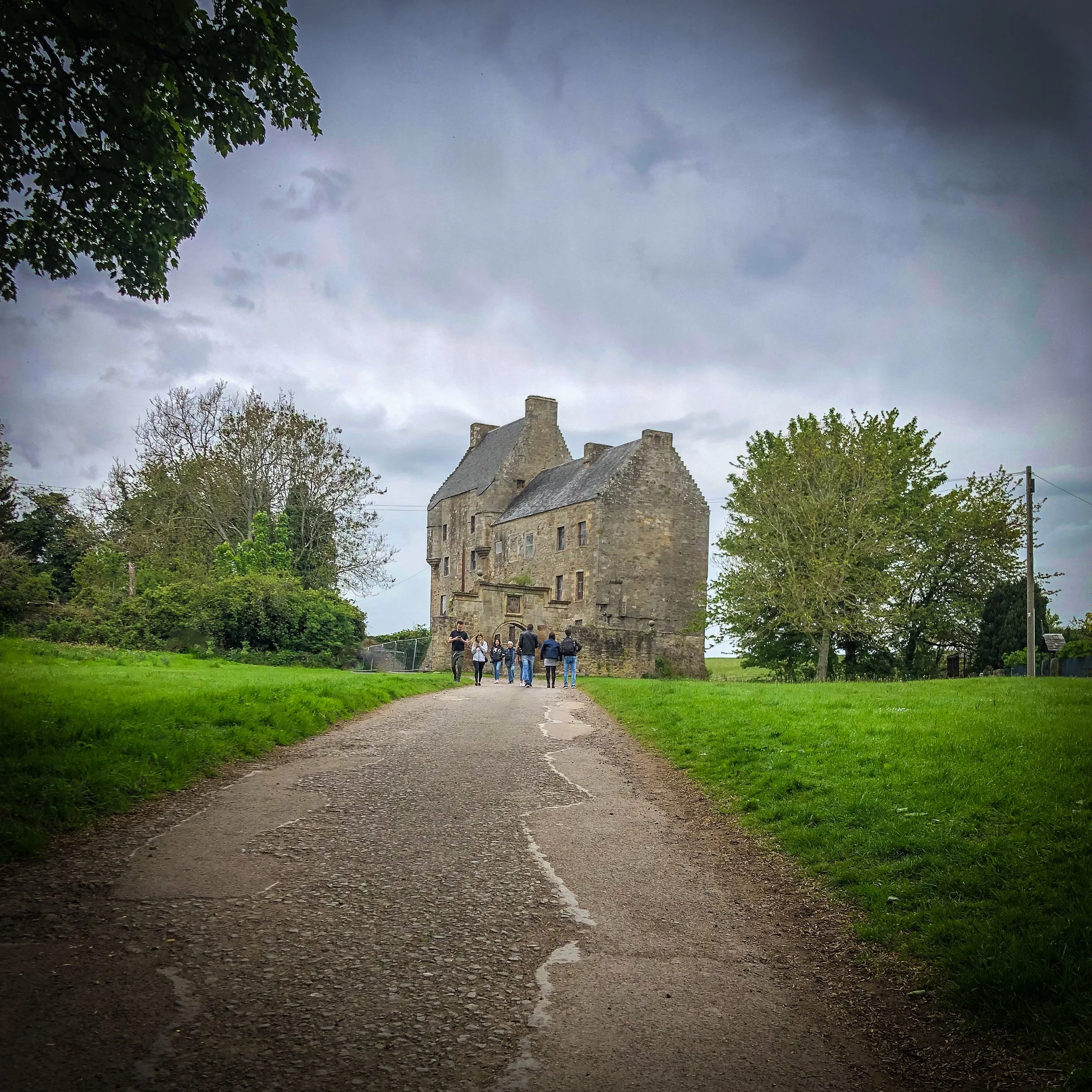 Midhope Castle, known as Lallybroch in Outlander, with visitors approaching Jamie Fraser's family home near Edinburgh, Scotland.