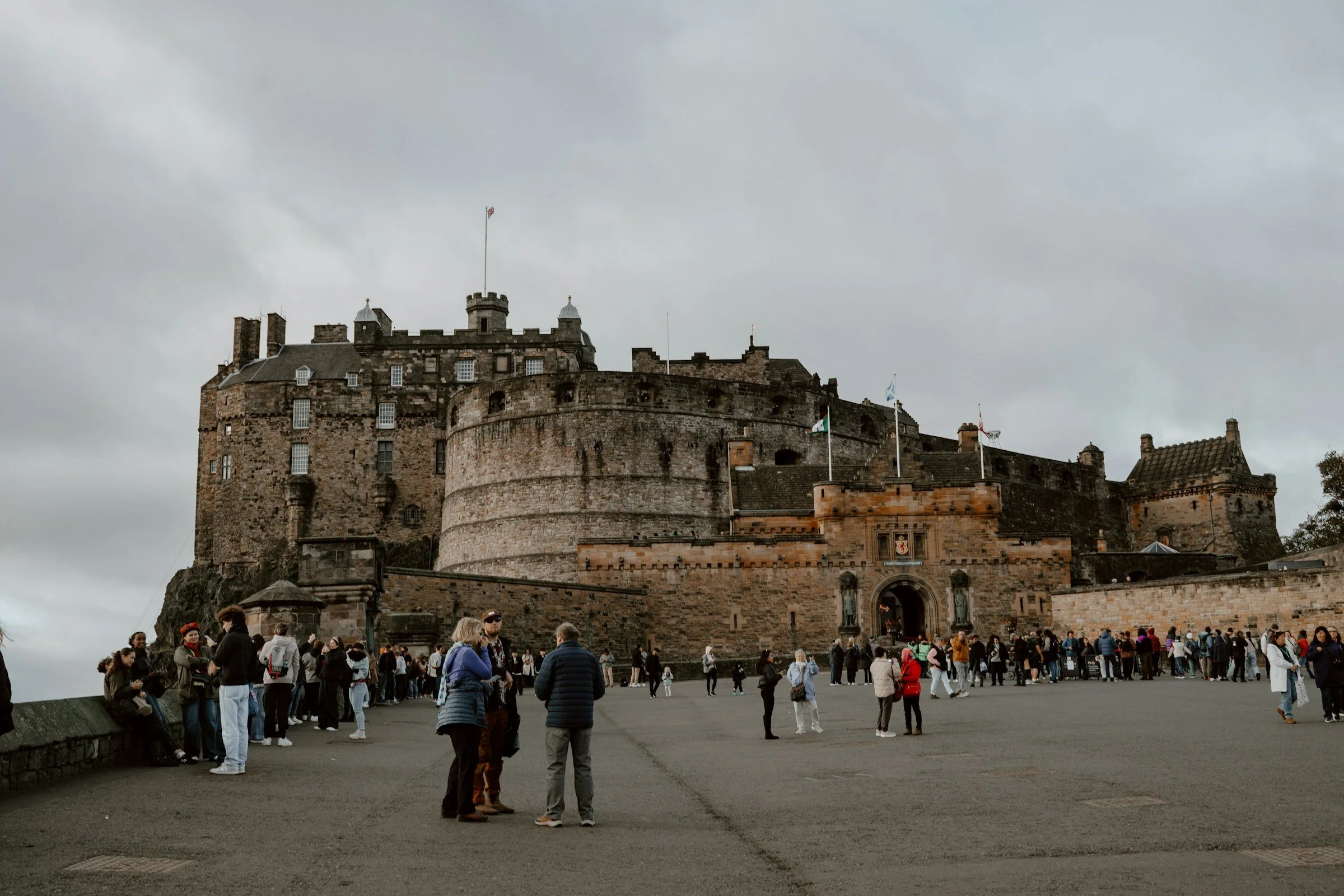 Visitors approaching the main entrance of Edinburgh Castle, with its imposing medieval stone walls and historic fortress overlooking Scotland's capital.