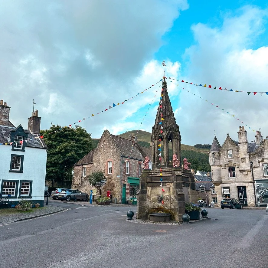 Village setting with a fountian in the middle of the street