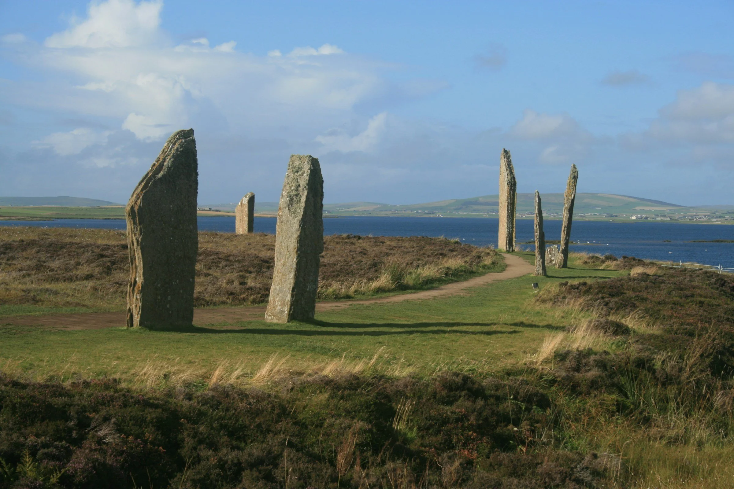 Standing stones at the Ring of Brodgar overlooking the Orkney landscape and Harray Loch.