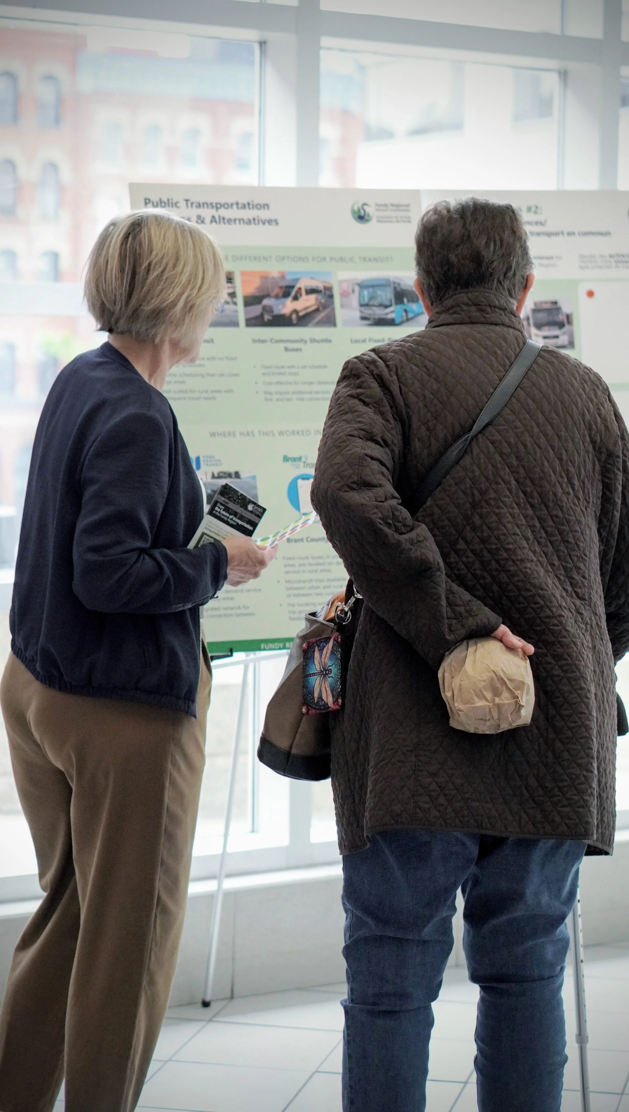 Two people look at an information board at a public engagement session