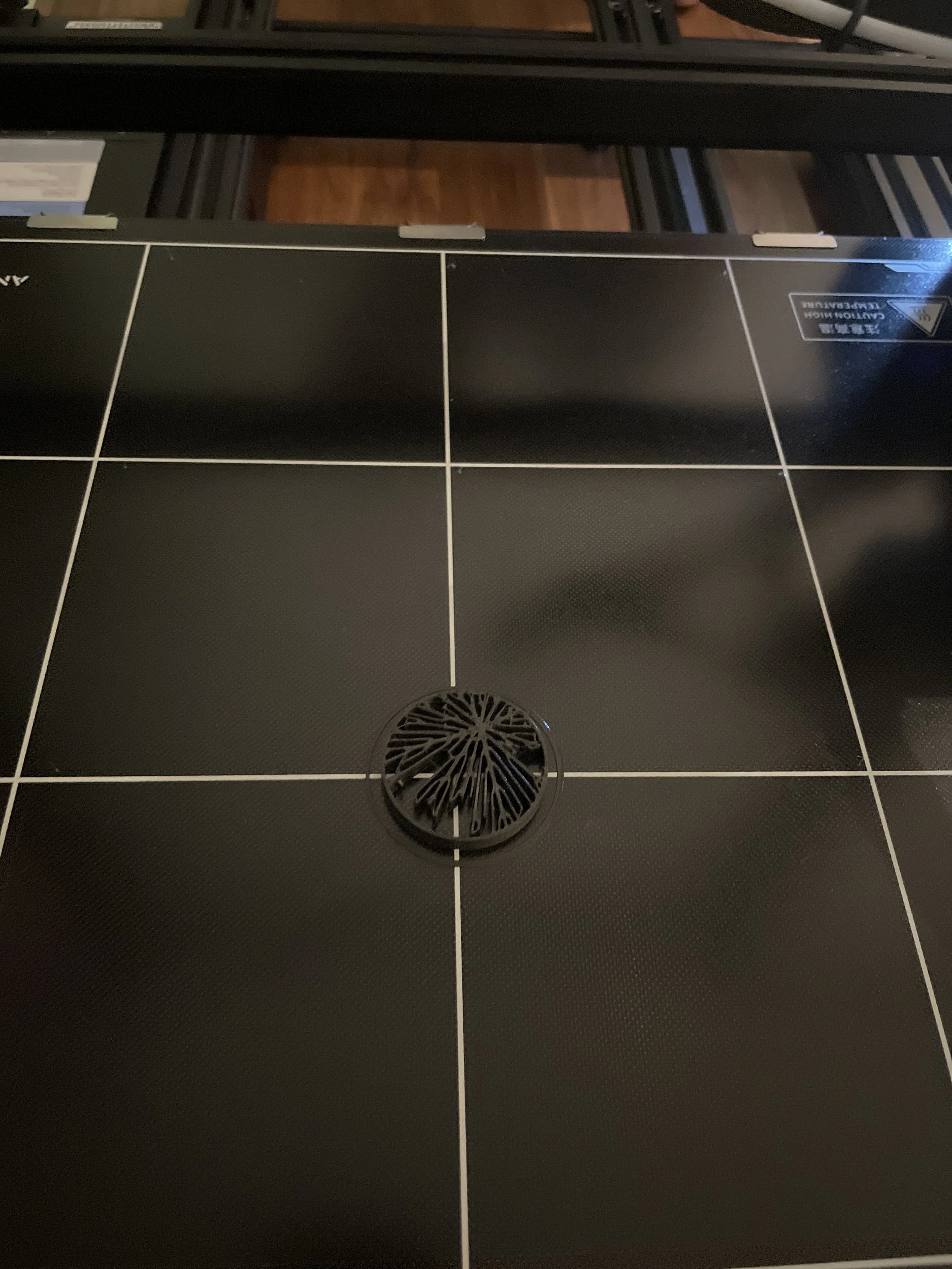 Black tiled surface with a round drain cover in the center and white grout lines, seen from above. Hypha Inc Marketing Agency and Creative Studio Lab, Tulum.