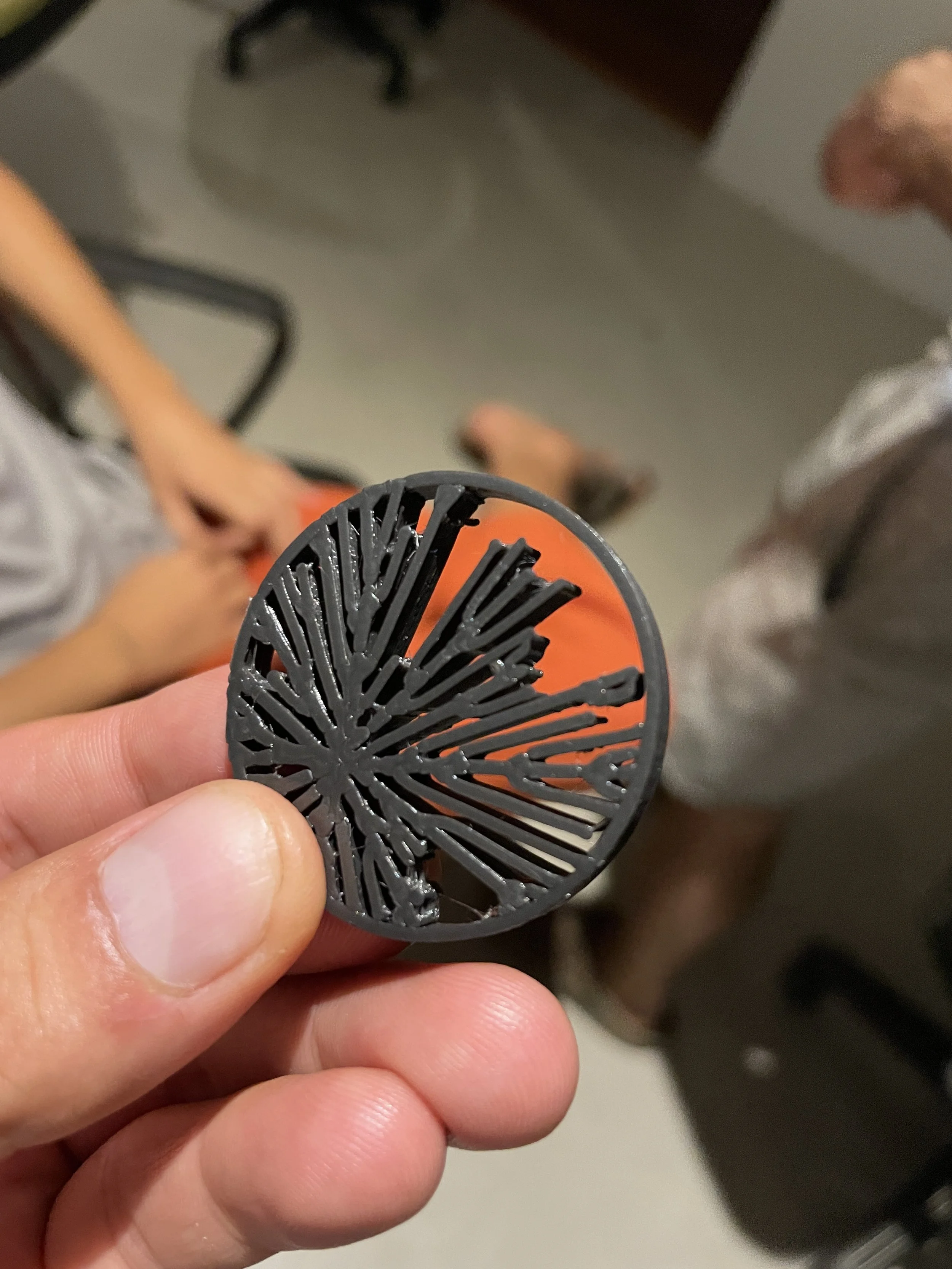 A person holding a black, circular plastic object with a grid-like pattern, with other people visible in the background. Hypha Inc. Digital Marketing & Advertising Agency, Tulum