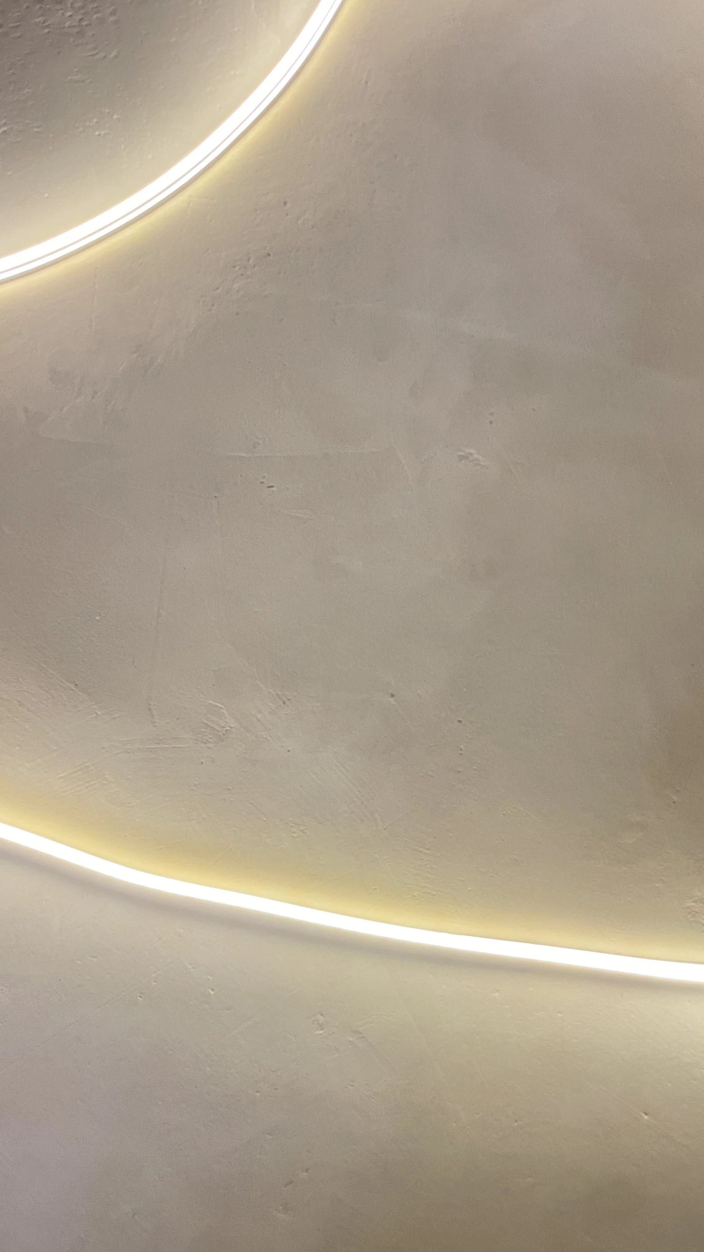 Close-up of a ceiling with a curved LED light strip emitting warm light. Hypha Inc Marketing Agency and Creative Studio Lab, Tulum.