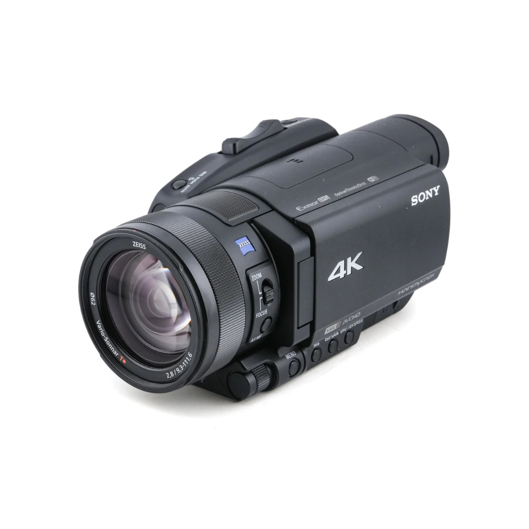 Black Sony 4K video camera with zoom lens on a white background.