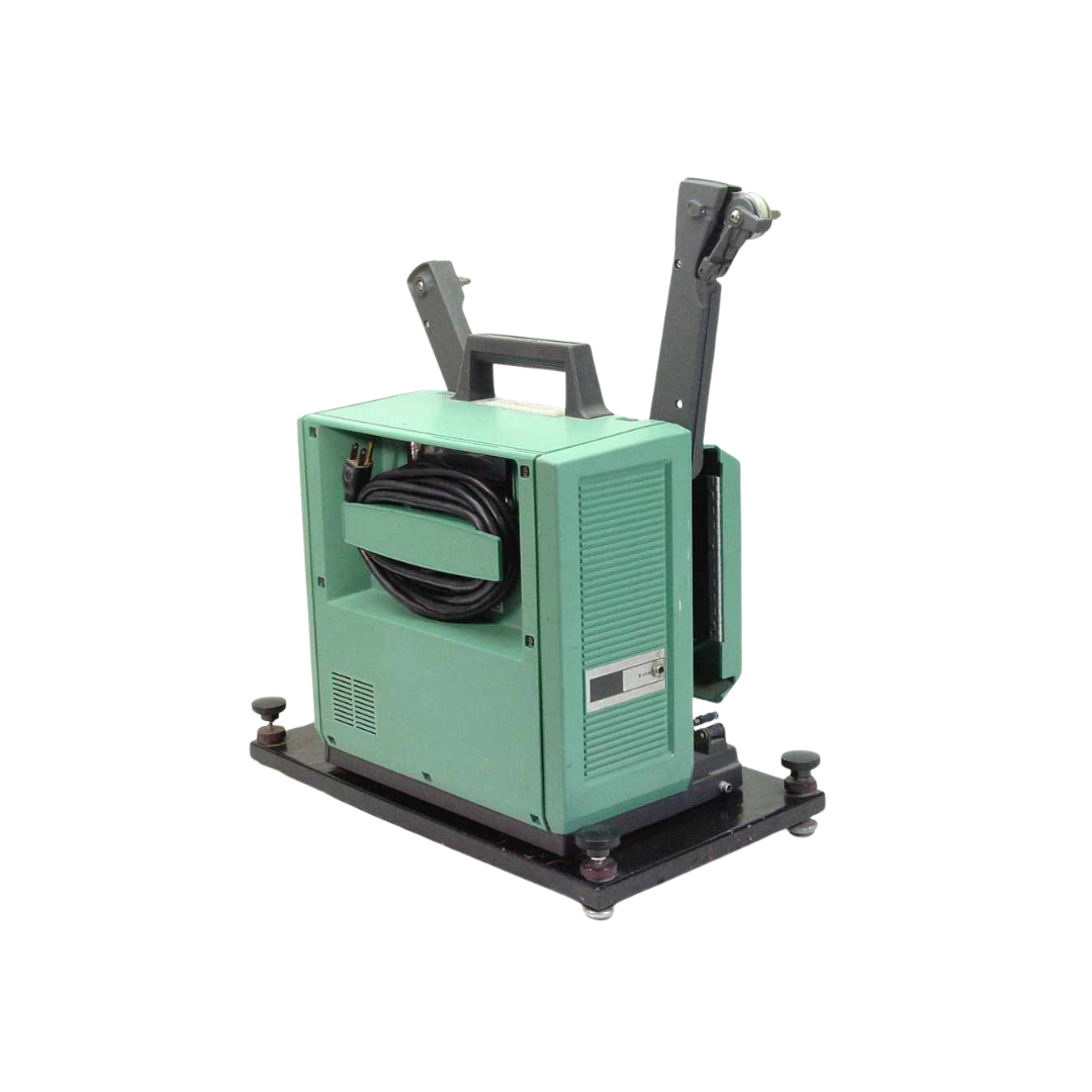 Green and black industrial machine with cables, set on a flat black base with adjustable feet.