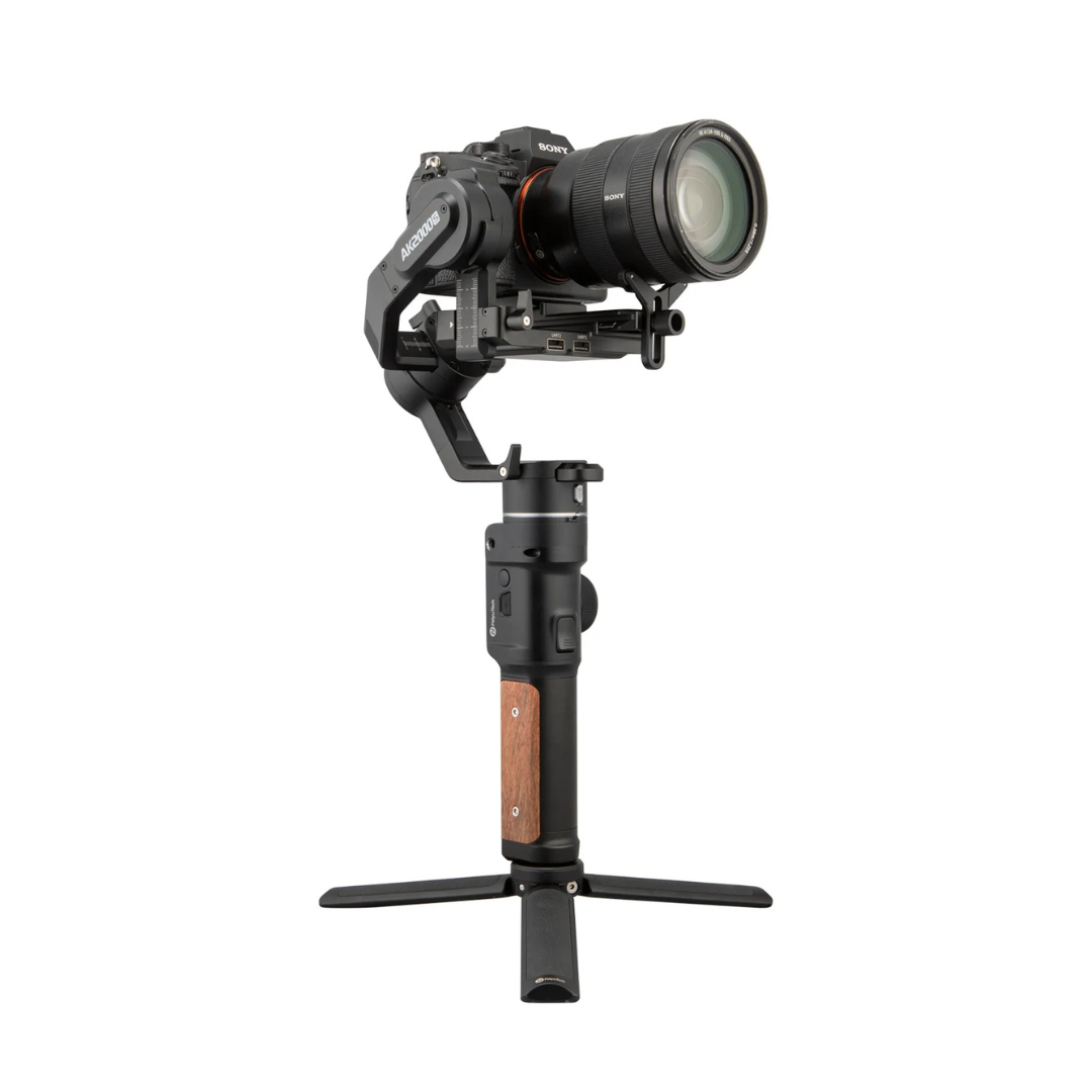 A professional camera mounted on a handheld stabilizer with tripod base against a plain white background.