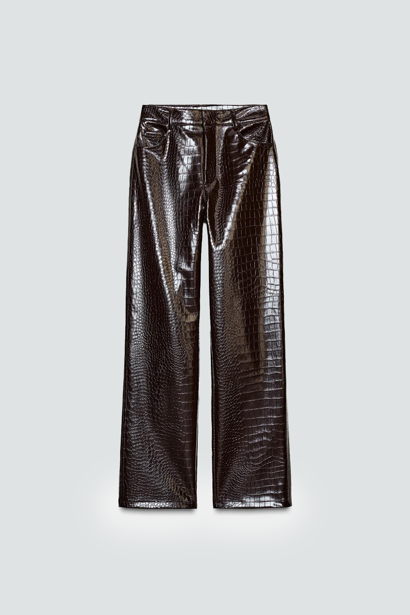 Pantalon en faux cuir à motif crocodile de couleur noire ou marron foncé.