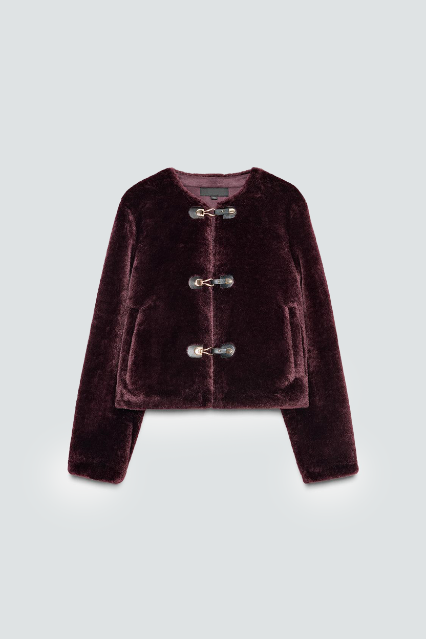 Veston en velours de couleur bordeaux avec des fermetures éclair ornementales à l'avant.